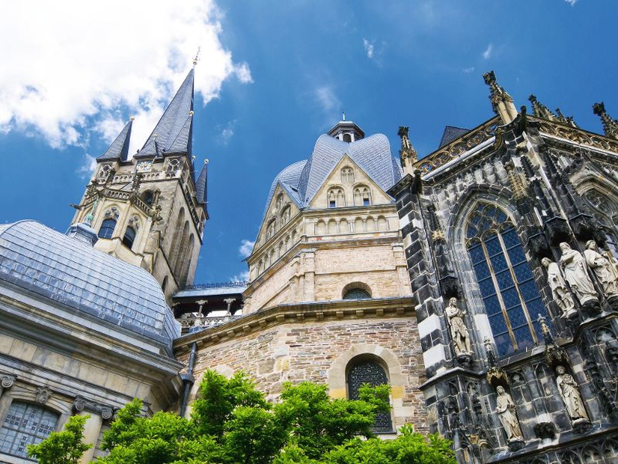 Kirchtürme und Fassade einer historischen Kirche vor blauem Himmel