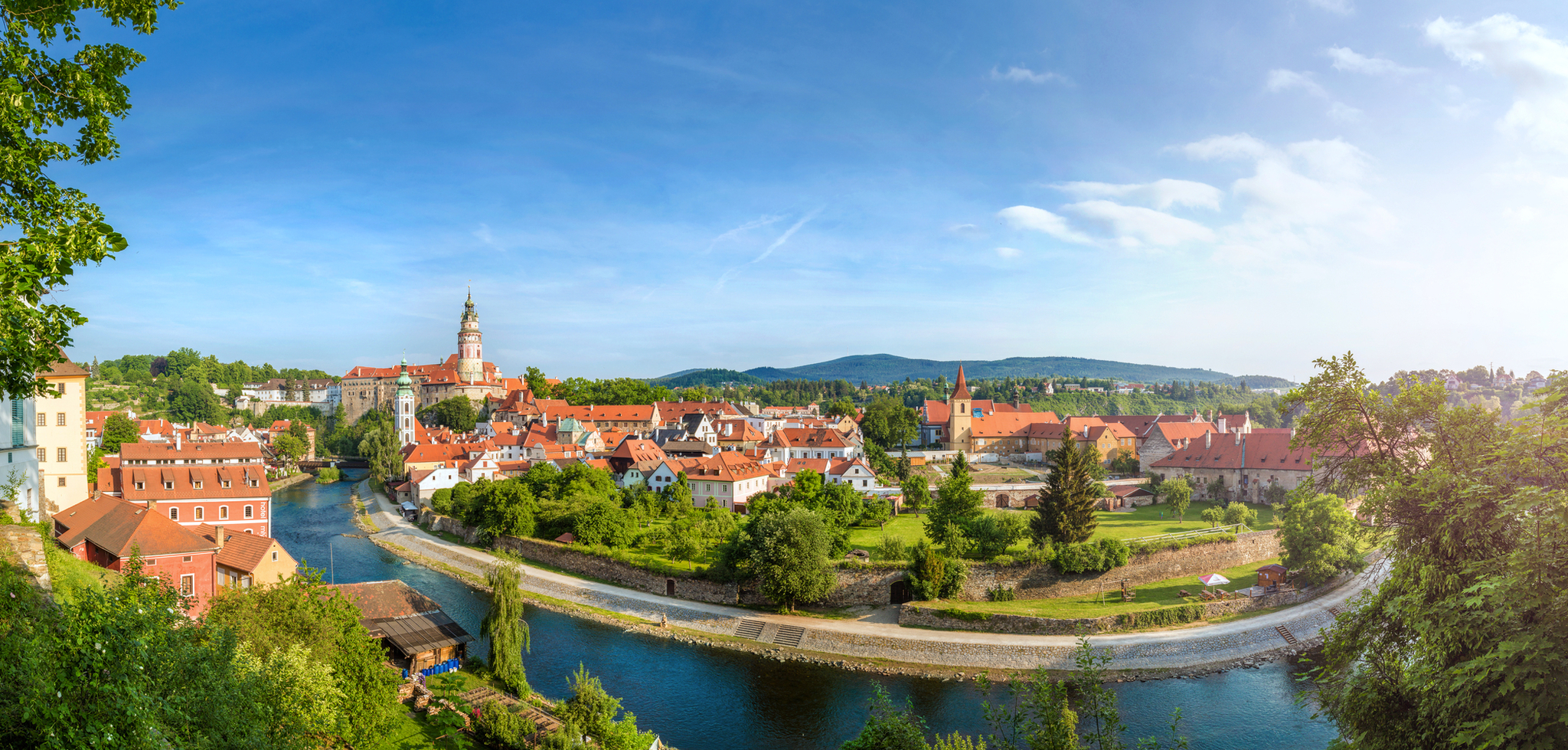 Panoramablick auf eine malerische Stadt mit Fluss und roter Ziegeldacharchitektur.