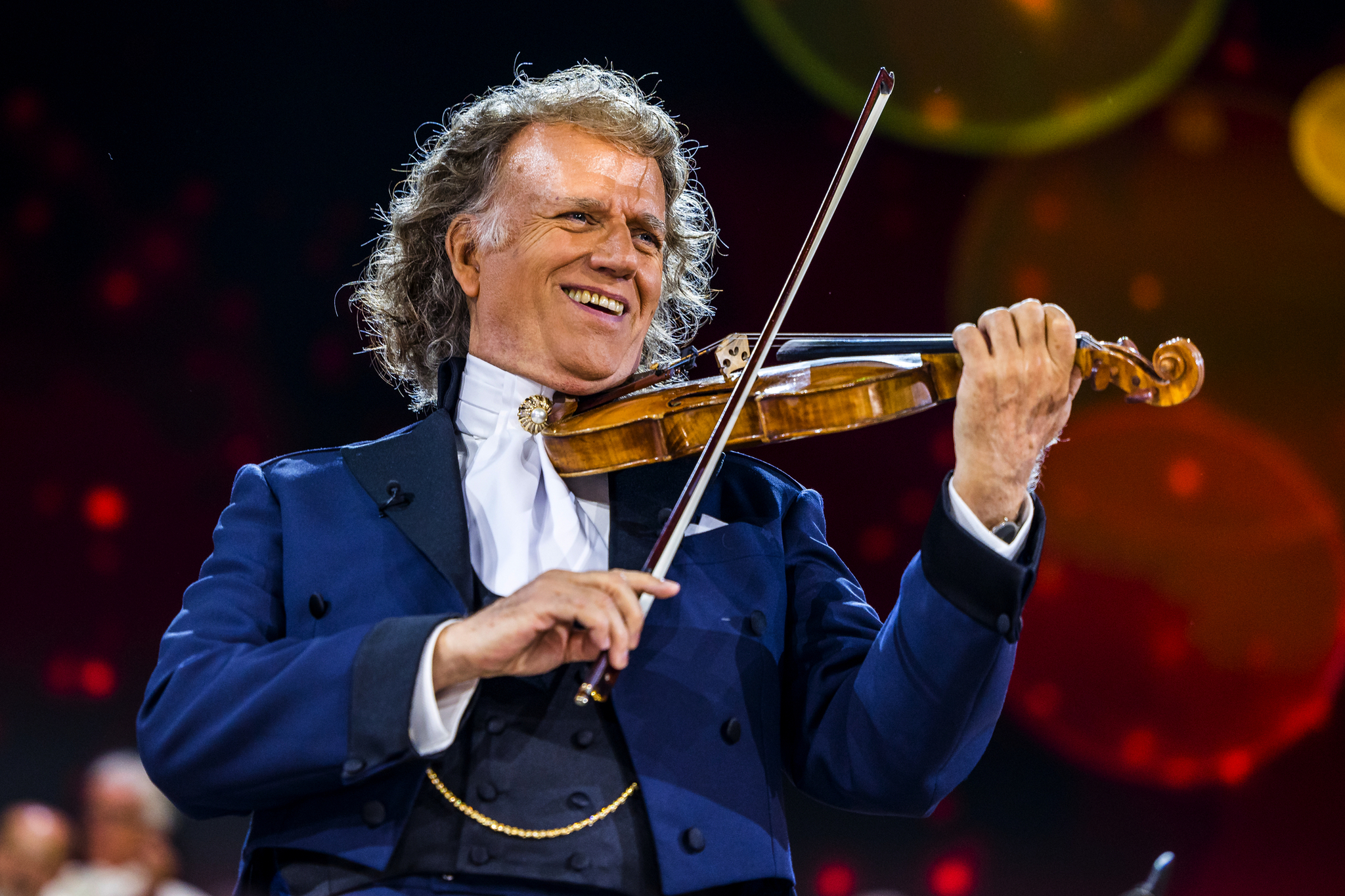 Ein Geiger spielt die Geige auf einem Konzert, möglicherweise Andre Rieu auf einer Bühne.