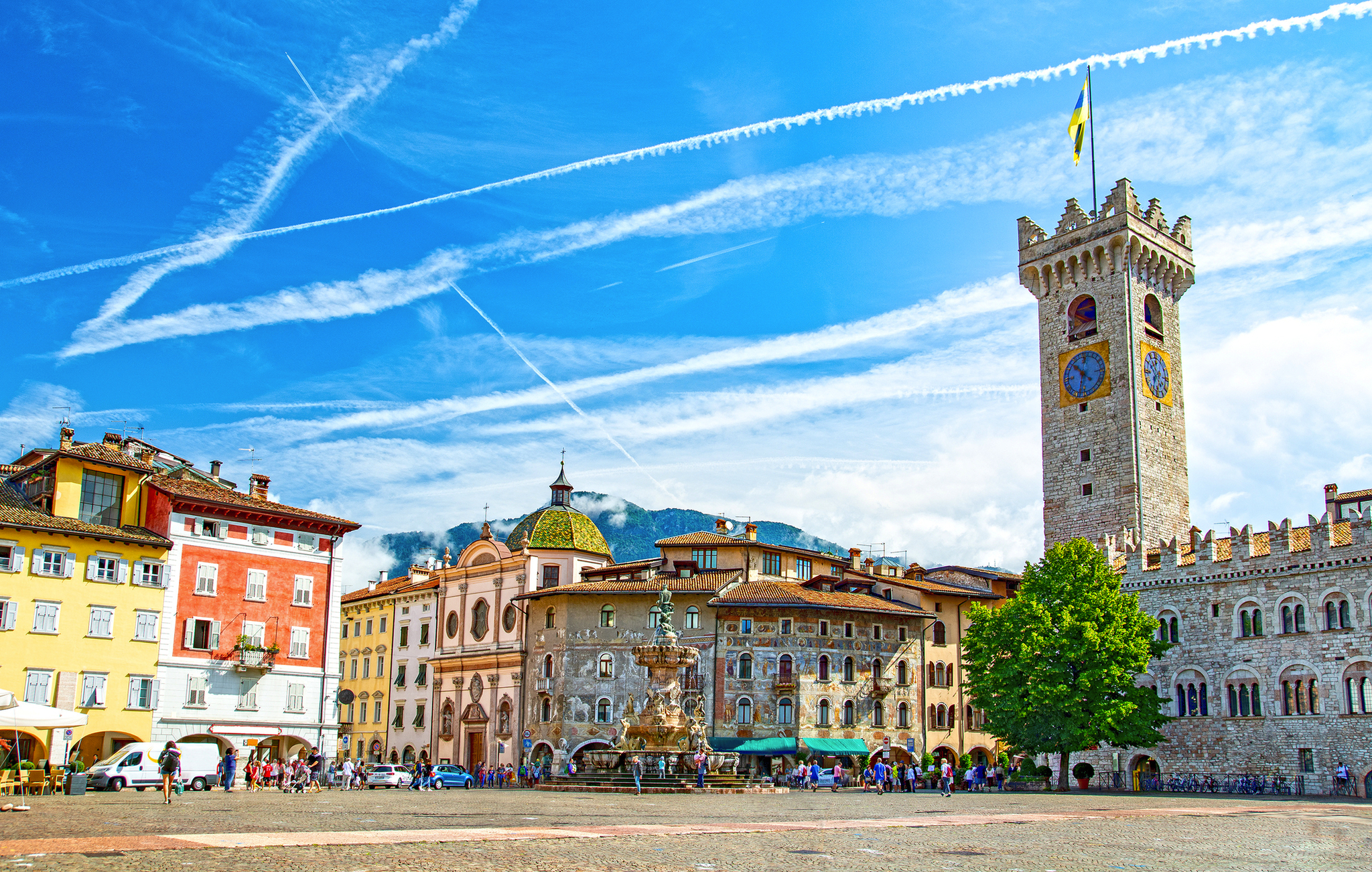 Historischer Platz mit bunt bemalten Gebäuden und Turm bei klarem Himmel.