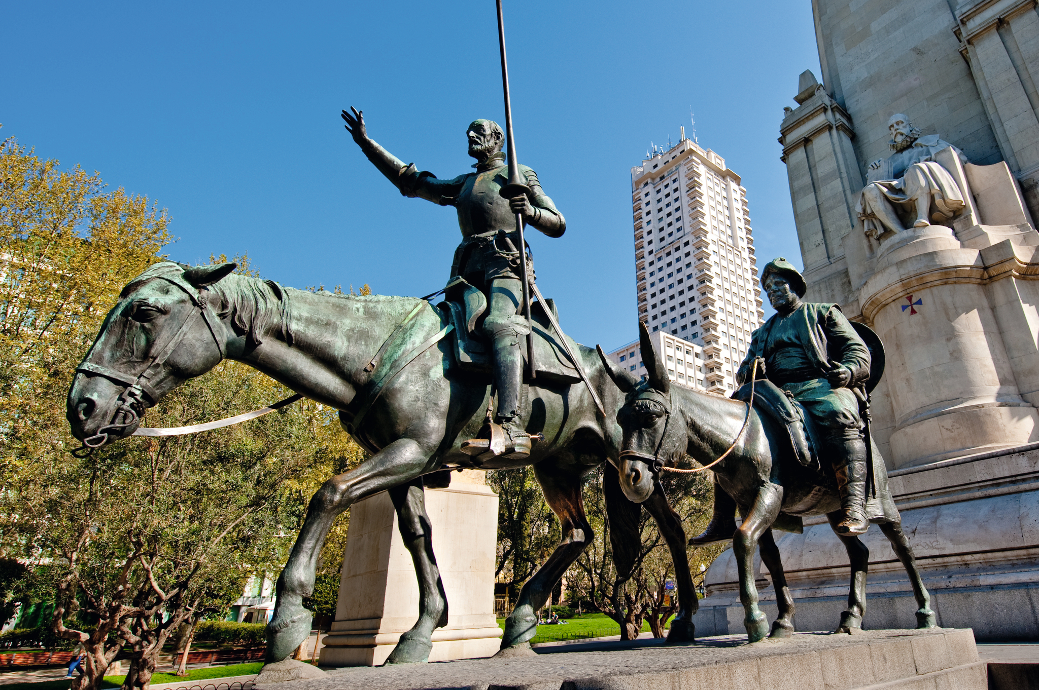 Bronzestatue von zwei Reitern in einem städtischen Park.