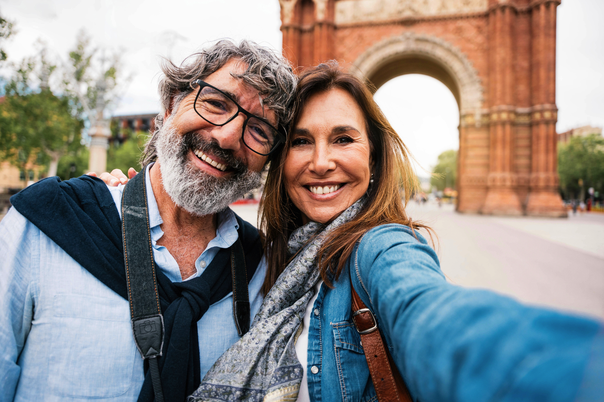 Ein lächelndes Paar macht ein Selfie vor einem Monument.