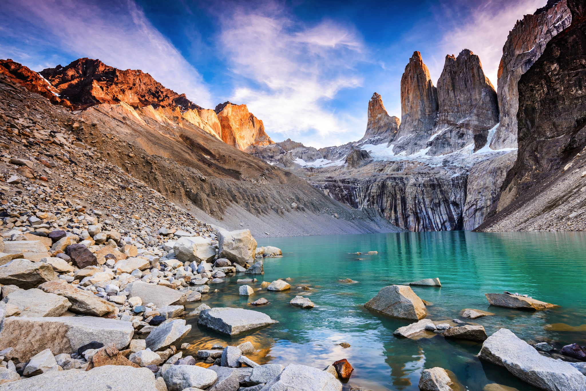 Blick auf türkisfarbenen Bergsee und Felsformationen bei Sonnenaufgang in Patagonien