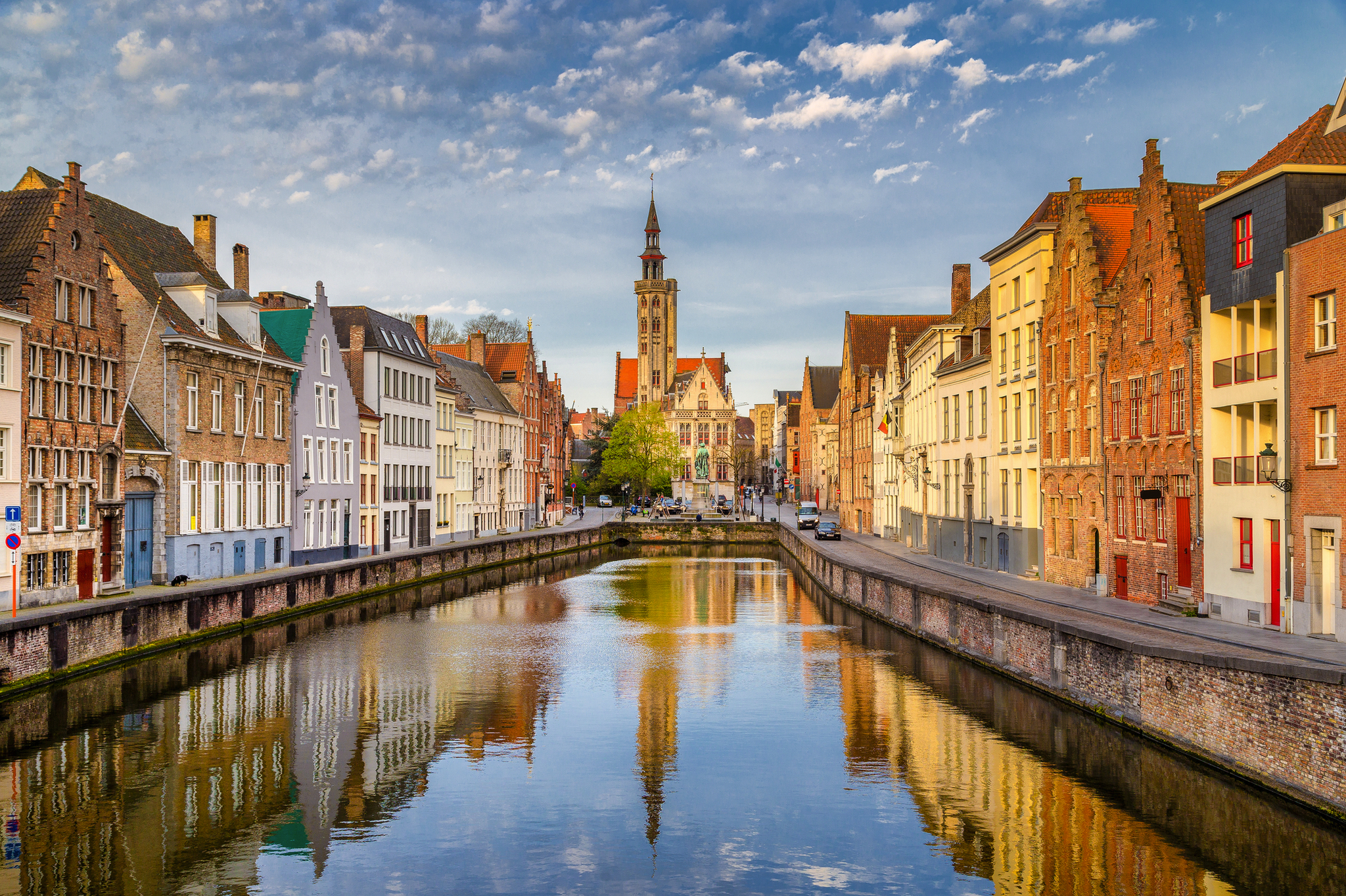 Historische Gebäude entlang eines Kanals in Brügge bei klarem Himmel.