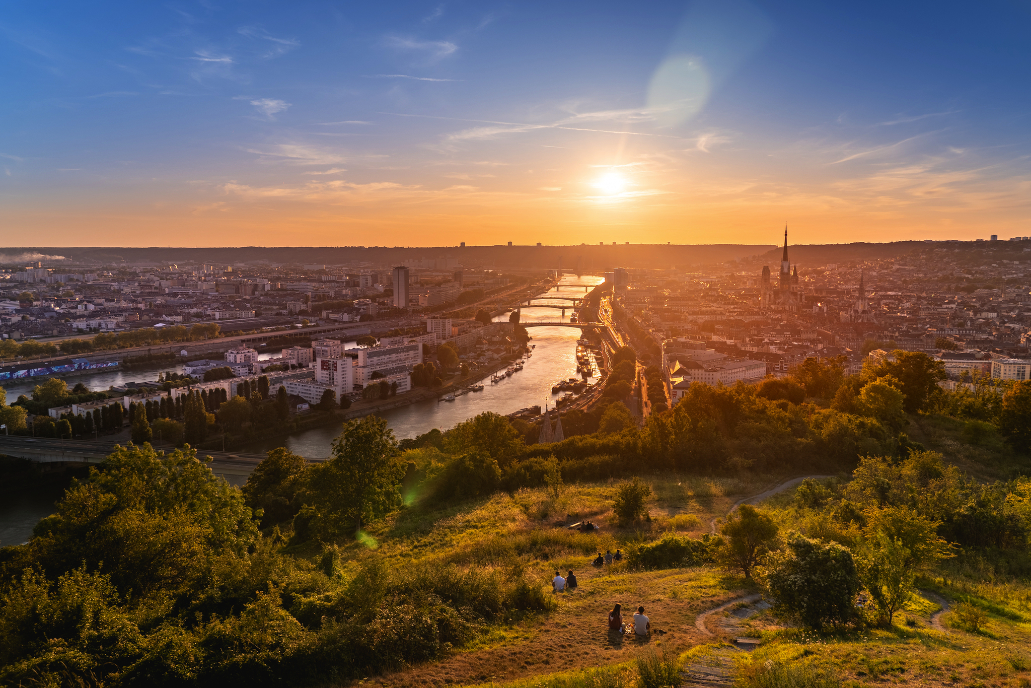 Stadtansicht von Paris bei Sonnenuntergang, Fluss und Eiffelturm im Hintergrund.