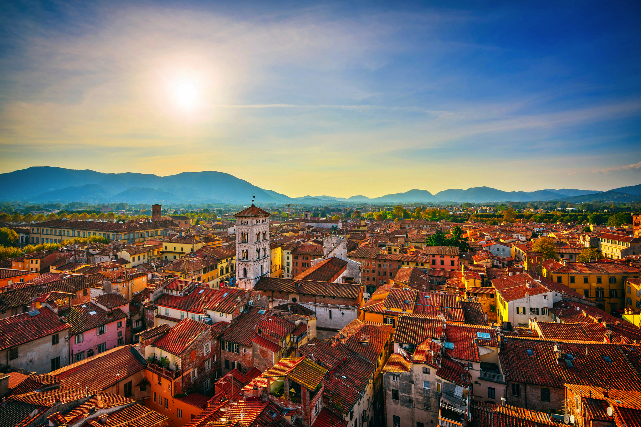 Lucca in der Toskana Stadtansicht bei Sonnenuntergang mit Bergen im Hintergrund.