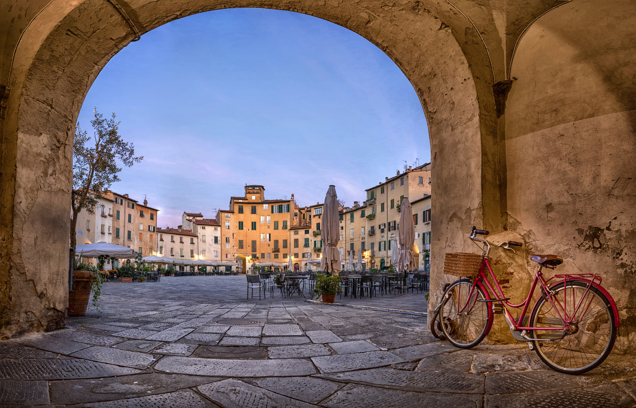 Blick auf die Piazza dell'Anfiteatro in Lucca Roter Fahrradrahmen in historischer Stadt mit Arkadenansicht, menschenleerer Platz.