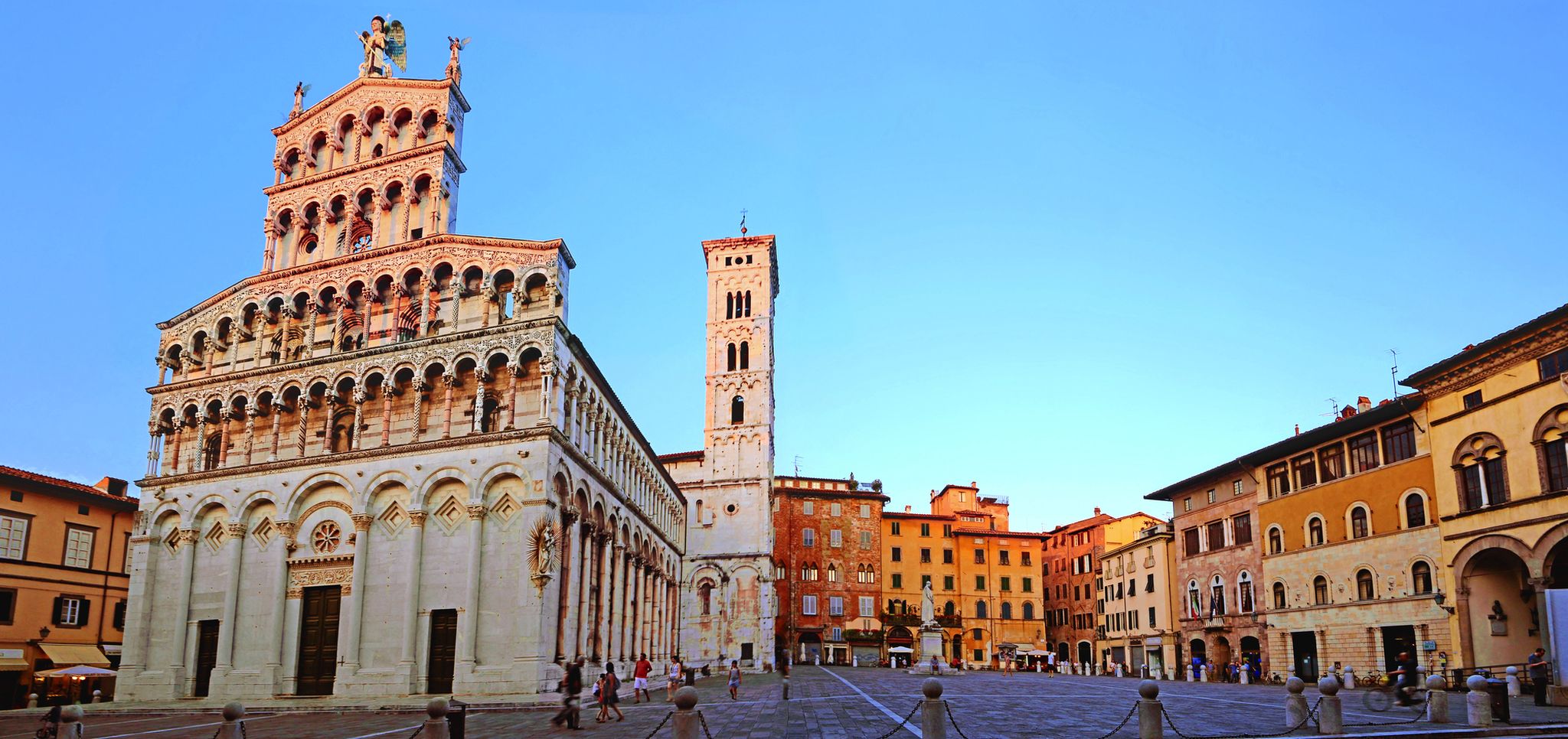 Kathedrale von Lucca Platz mit historischer Kathedrale und Gebäuden unter klarem Himmel.