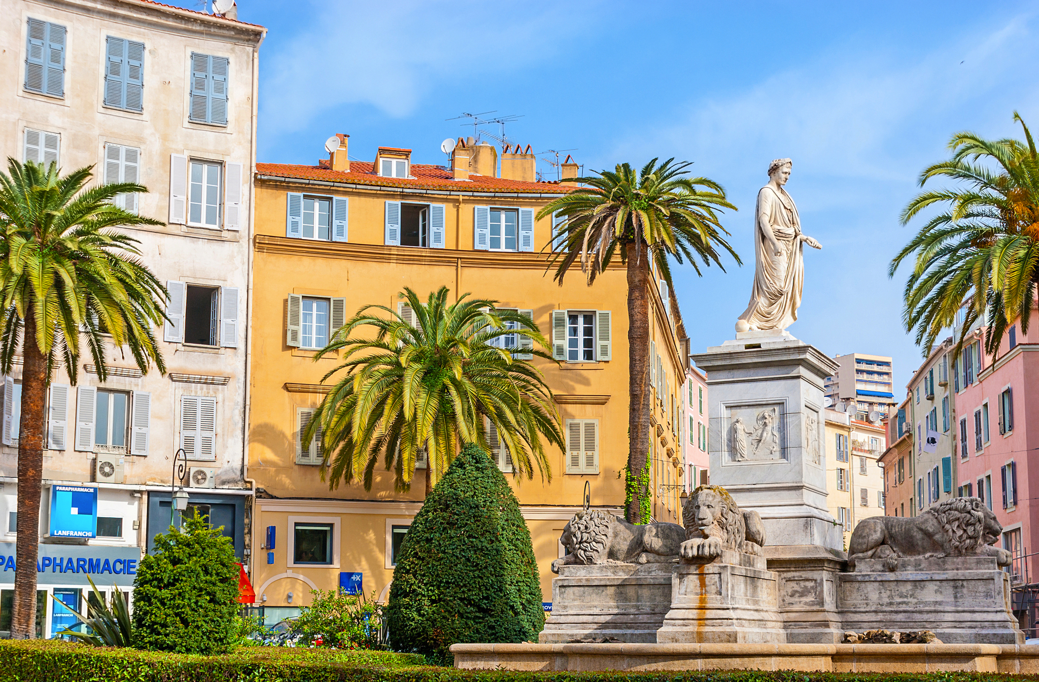 Statue von Napoleon in Ajaccio auf Korsika umgeben von Palmen.