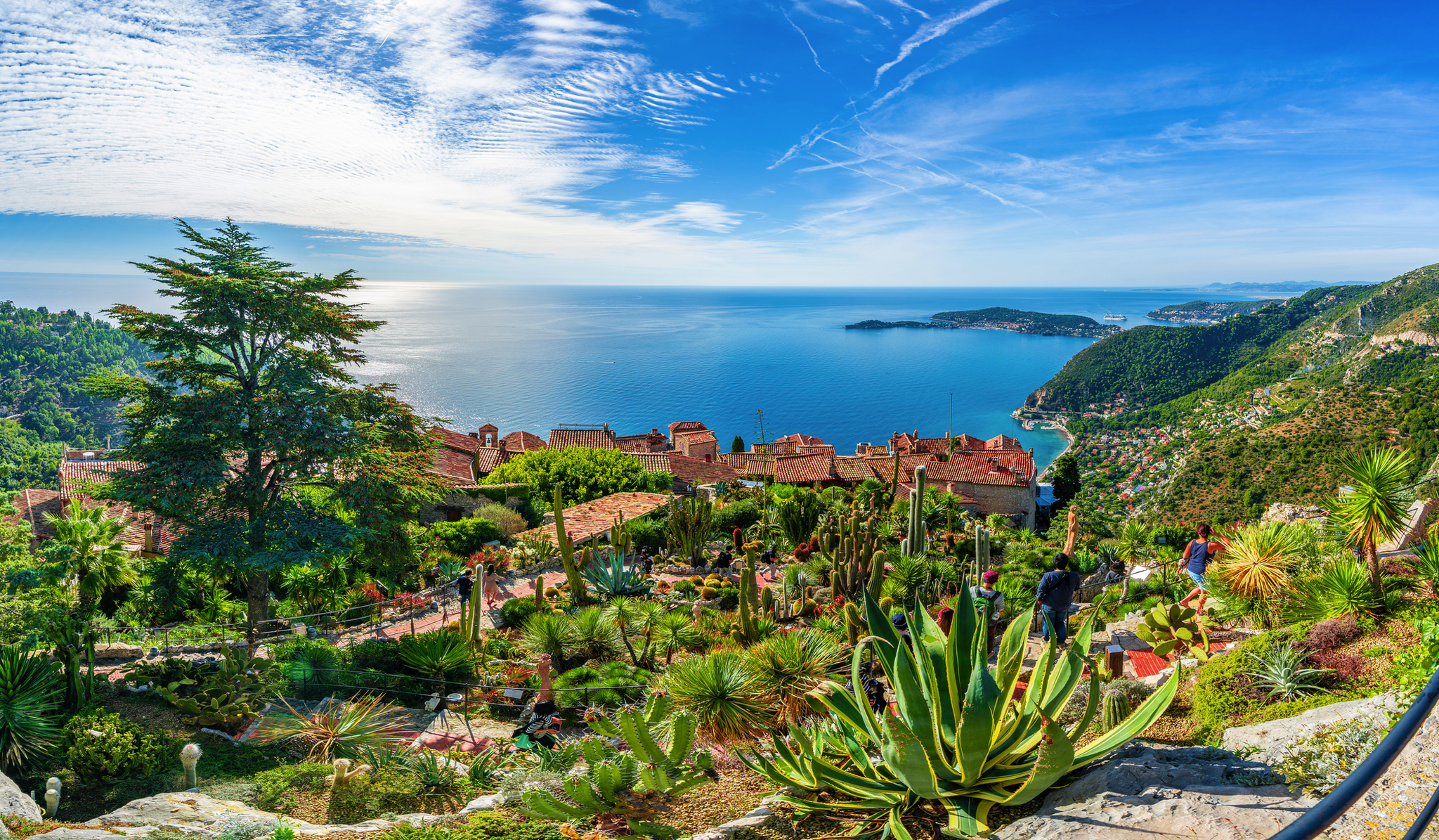 Aussicht auf eine Küstenlandschaft mit blauem Meer und grüner Vegetation.