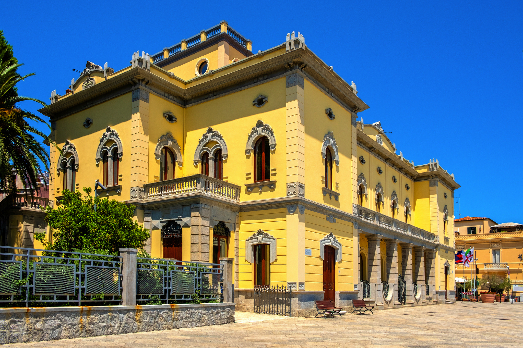 Gelbes historisches Gebäude mit dekorativen Fenstern und blauem Himmel.