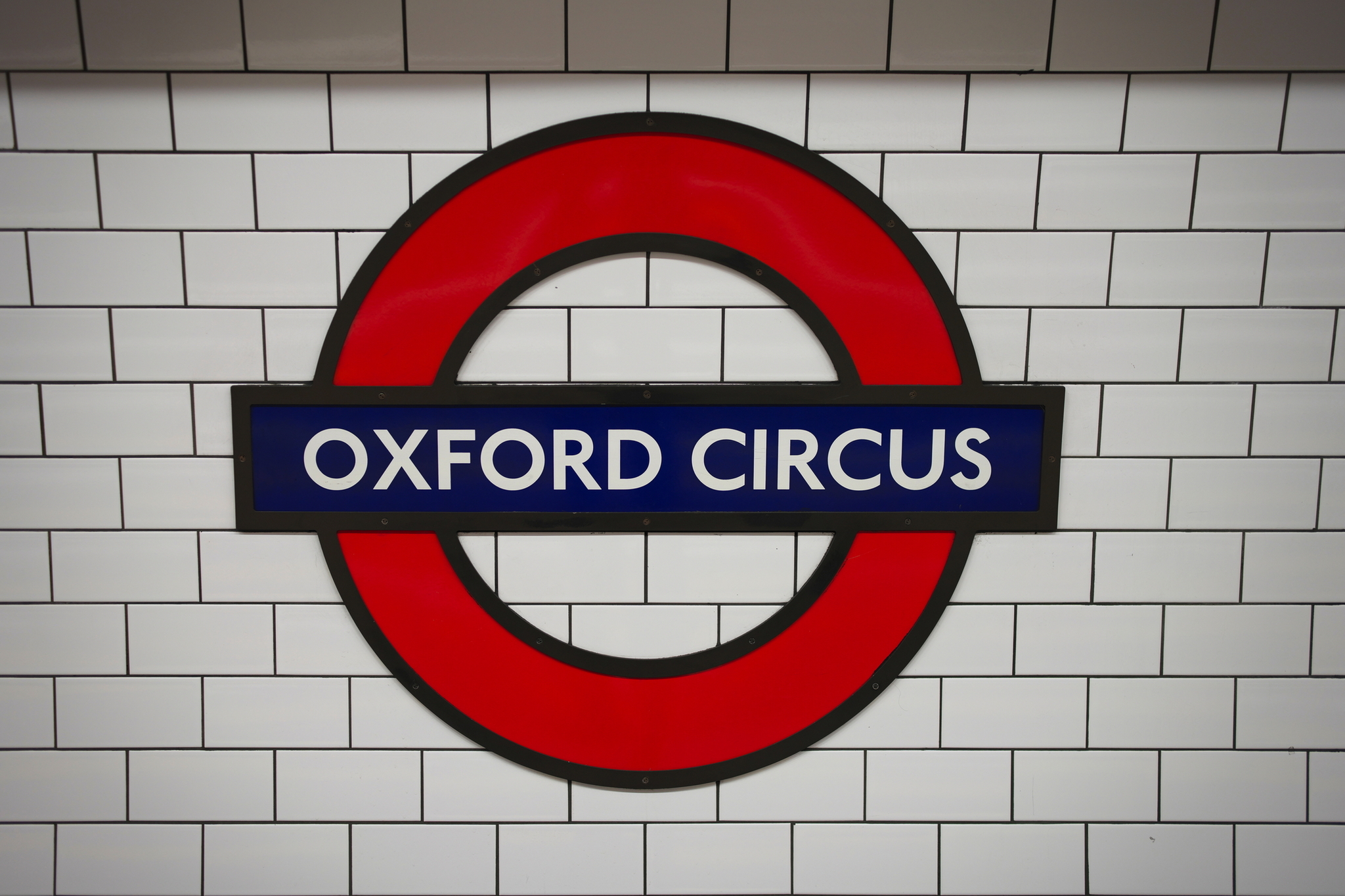 Rundes Oxford Circus U-Bahn-Schild vor weißer Fliesenwand.