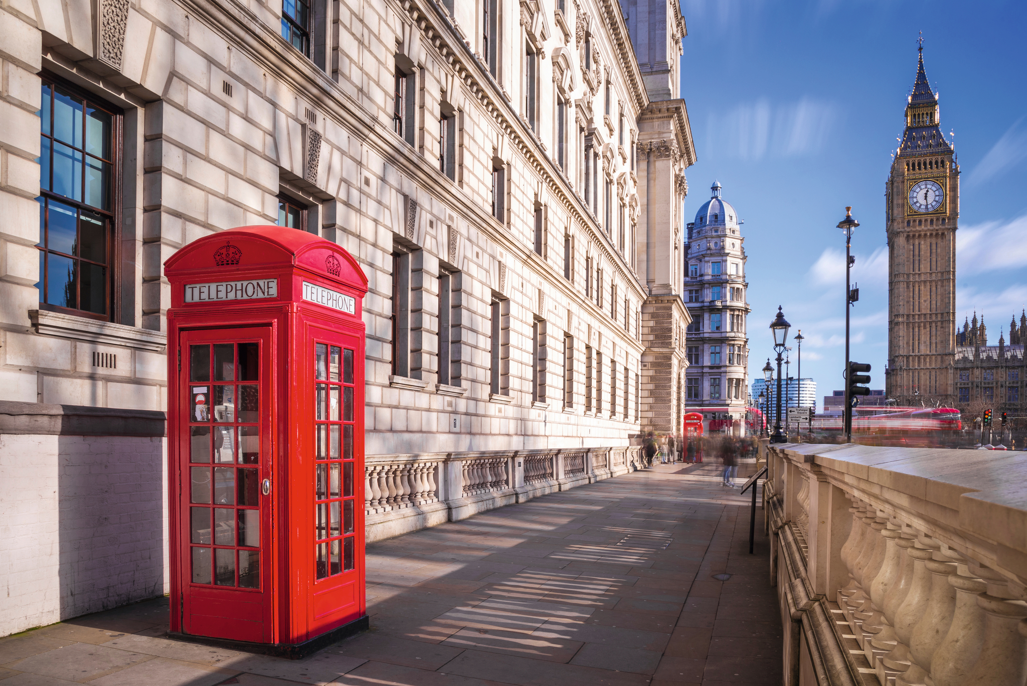 Rote Telefonzelle vor dem Big Ben und einem roten Doppeldeckerbus in London, Großbritannien.