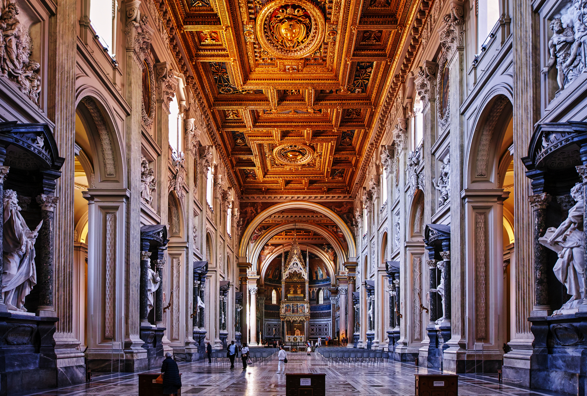 Prächtige Innenansicht einer reich verzierten, historischen Kathedrale mit goldener Decke.