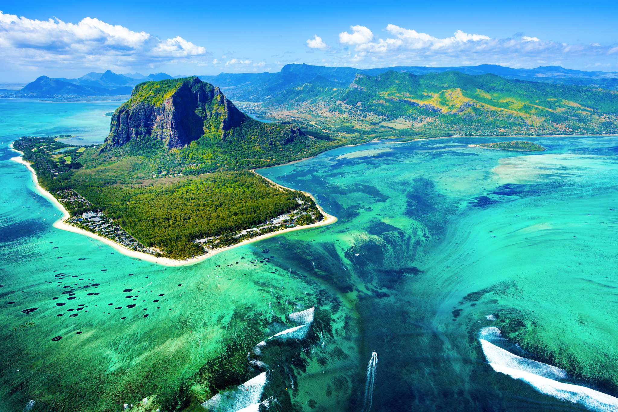 Luftaufnahme einer tropischen Insel mit Strand und türkisfarbenem Meer.