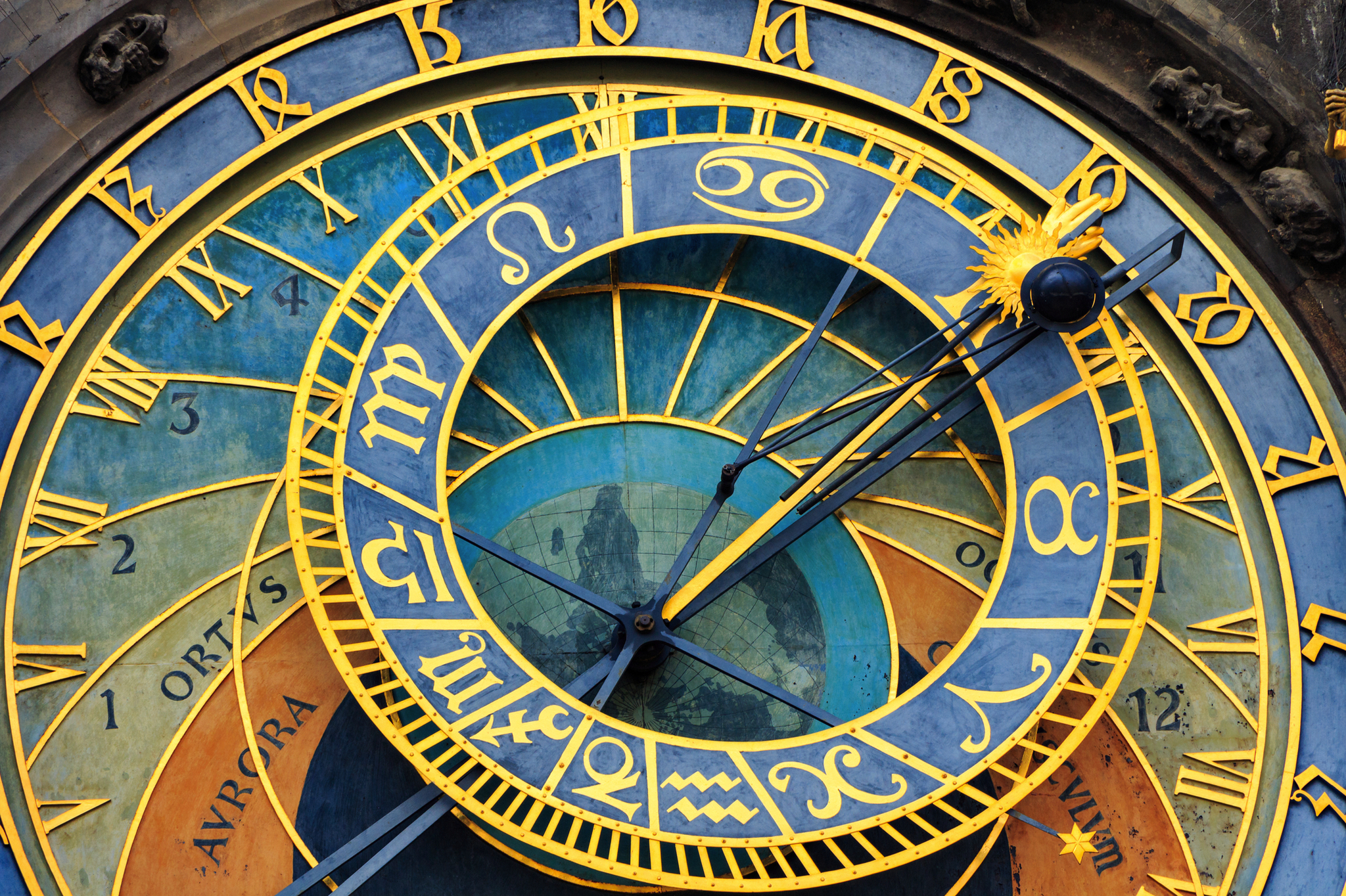 Nahaufnahme einer astronomischen Uhr mit Tierkreiszeichen und römischen Ziffern.