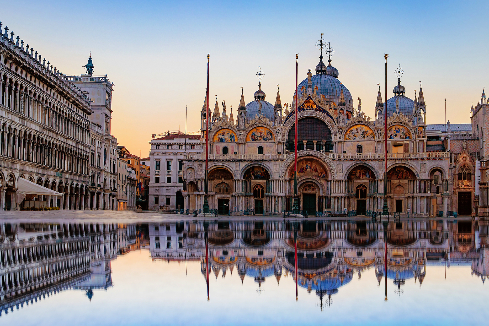 Sonnenaufgang auf dem Markusplatz mit Campanile und Markusdom in Venedig Basilika San Marco bei Sonnenaufgang mit Spiegelung im Wasser.