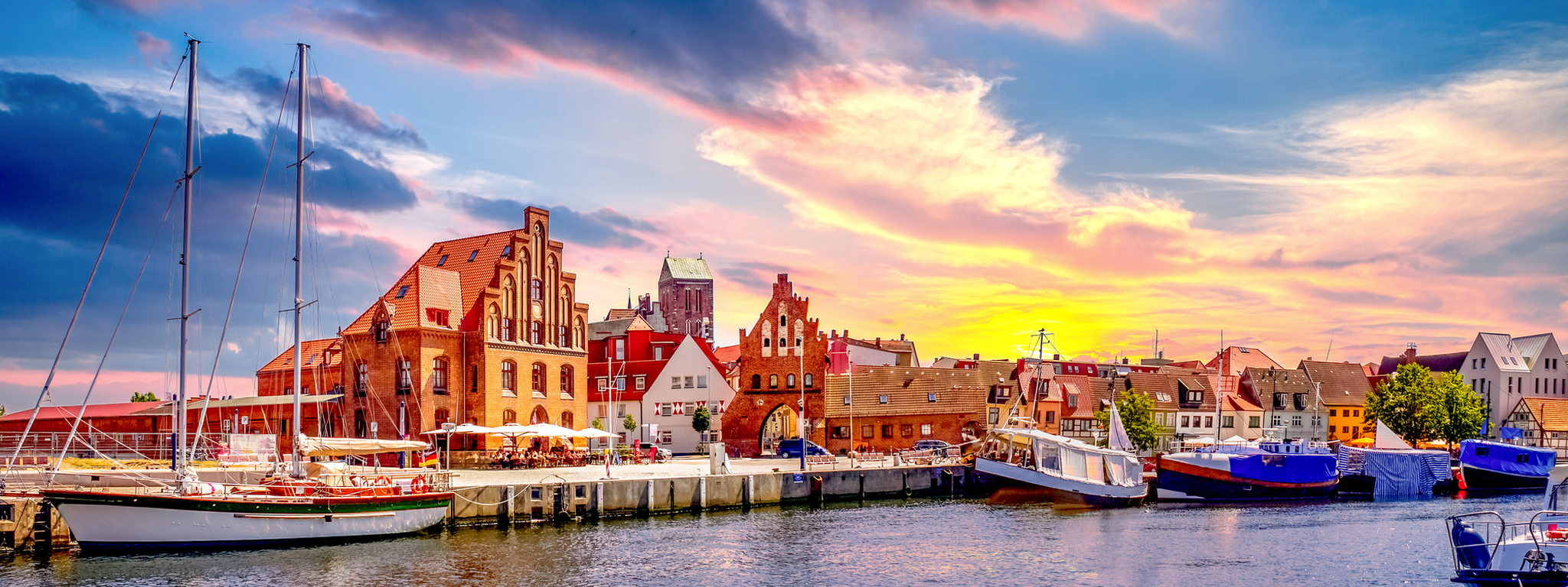 Alter Hafen von Wismar an der Ostseeküste mit Blick auf die Altstadt bei Sonnenuntergang in Mecklenburg-Vorpommern, Deutschland.