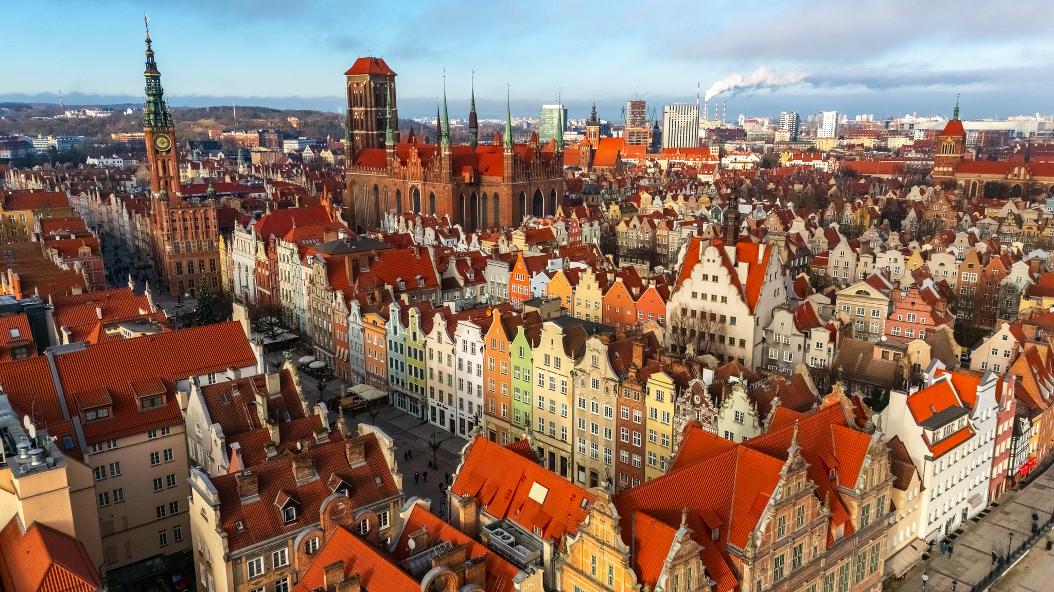 Luftaufnahme von Gdansk im Winter mit schneebedeckten Dächern und historischen Gebäuden.