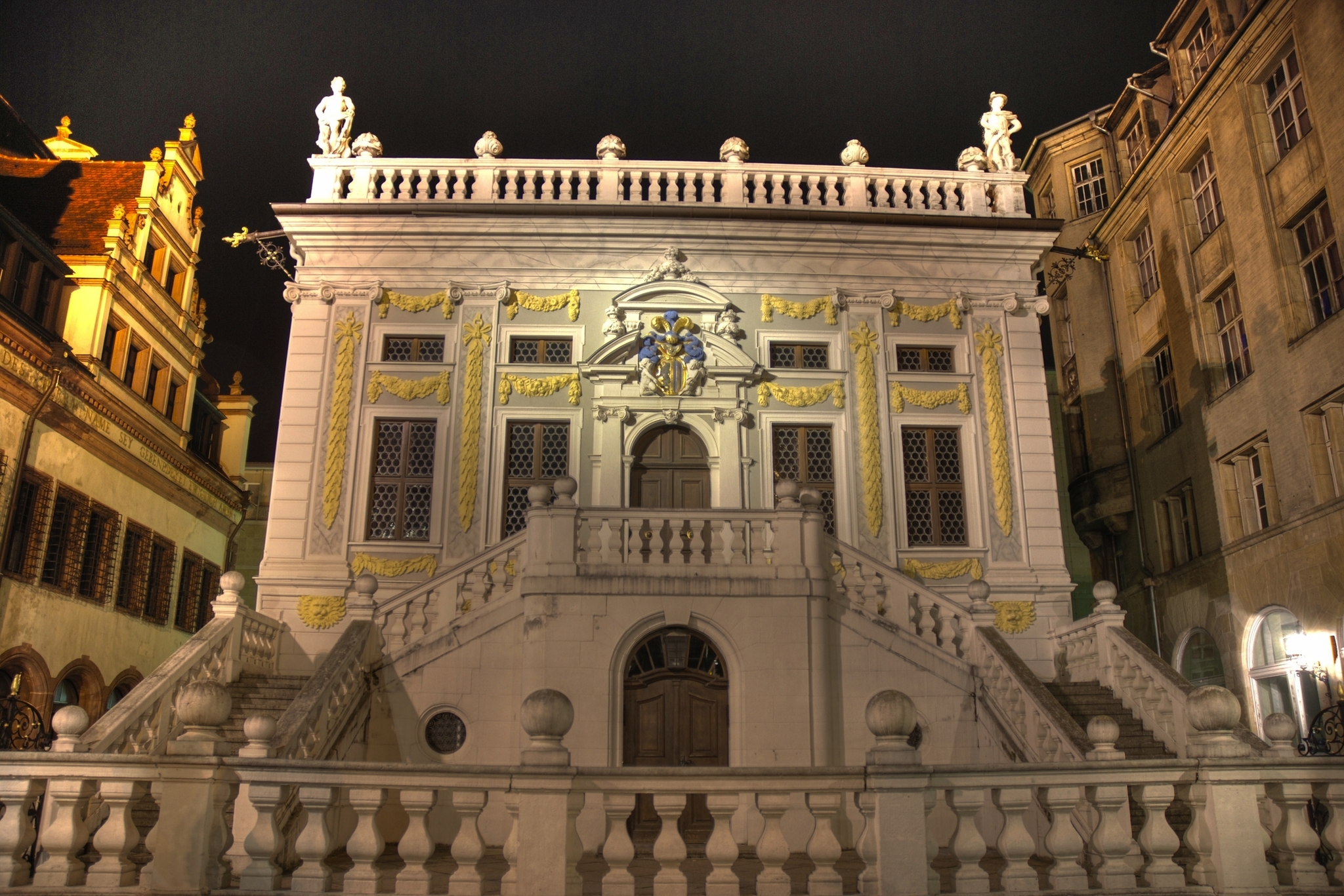 Historisches Gebäude mit Treppen und verzierter Fassade bei Nacht.