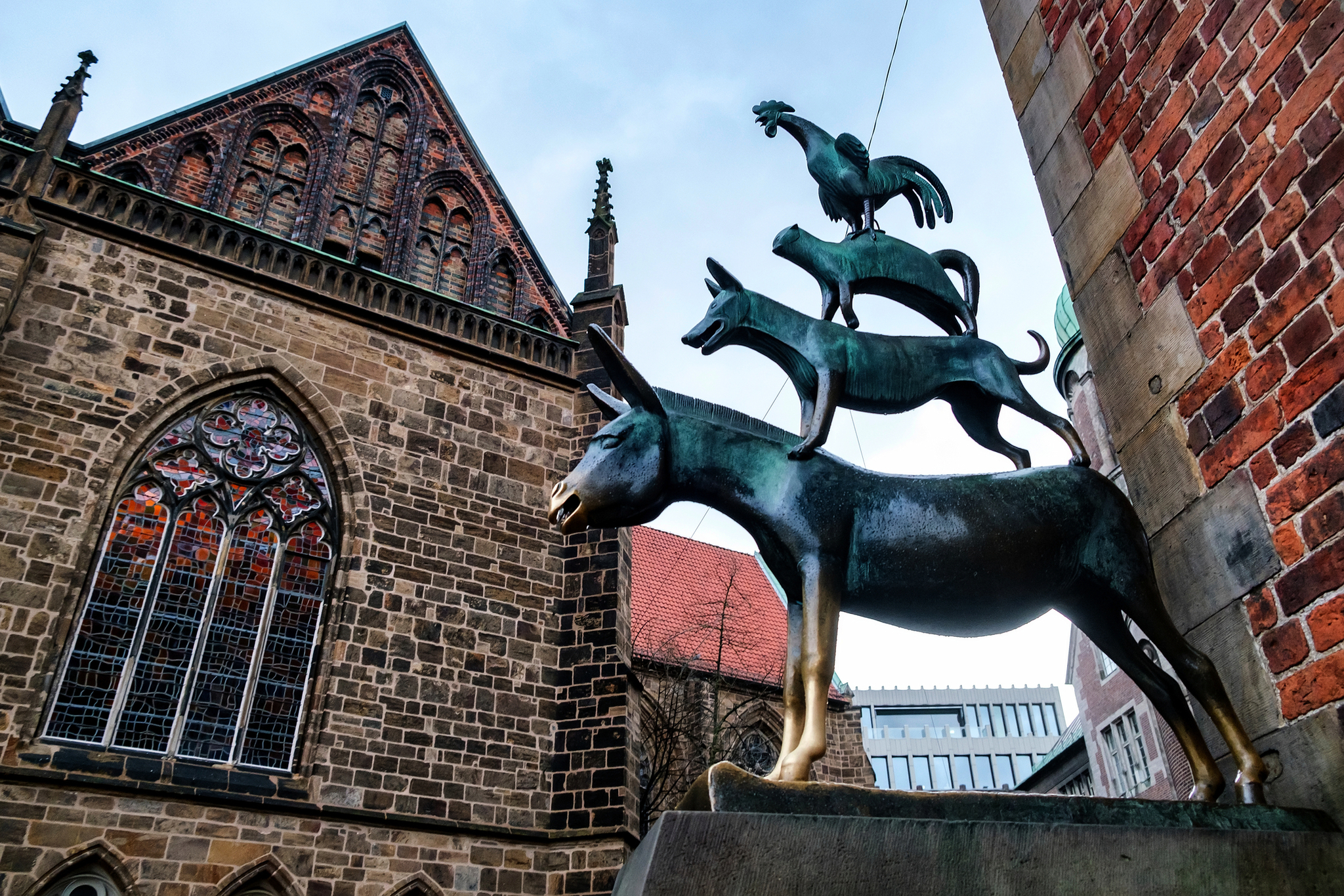 Bremer Stadtmusikanten Skulptur der Bremer Stadtmusikanten vor historischer Kirche in Bremen, Deutschland.