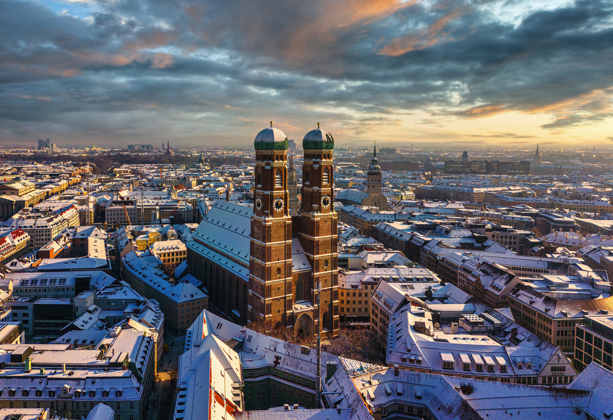 Verschneite Stadtansicht von München mit der Frauenkirche im Zentrum.