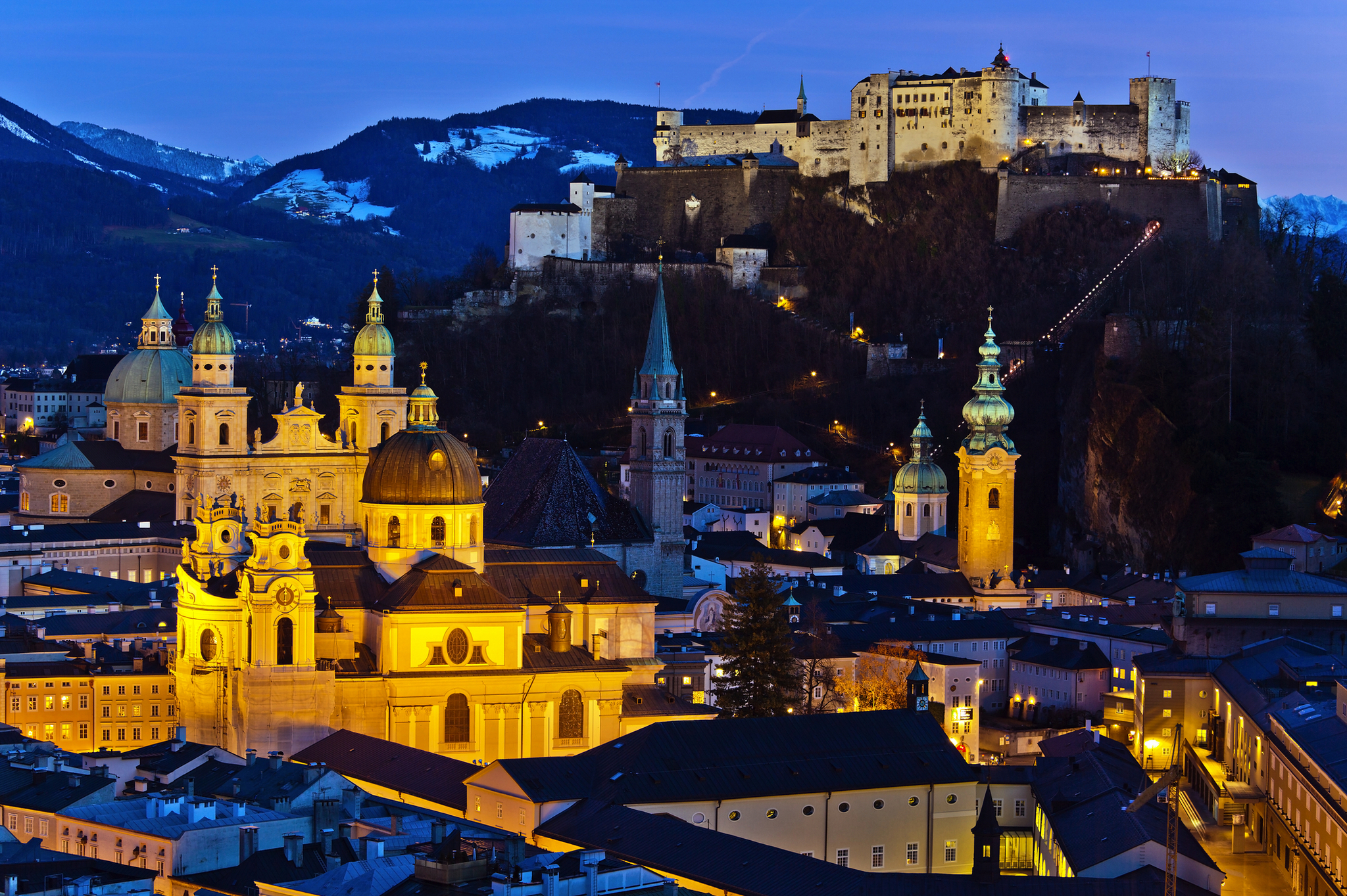 Blick auf Salzburg bei Dämmerung mit Festung Hohensalzburg im Hintergrund.