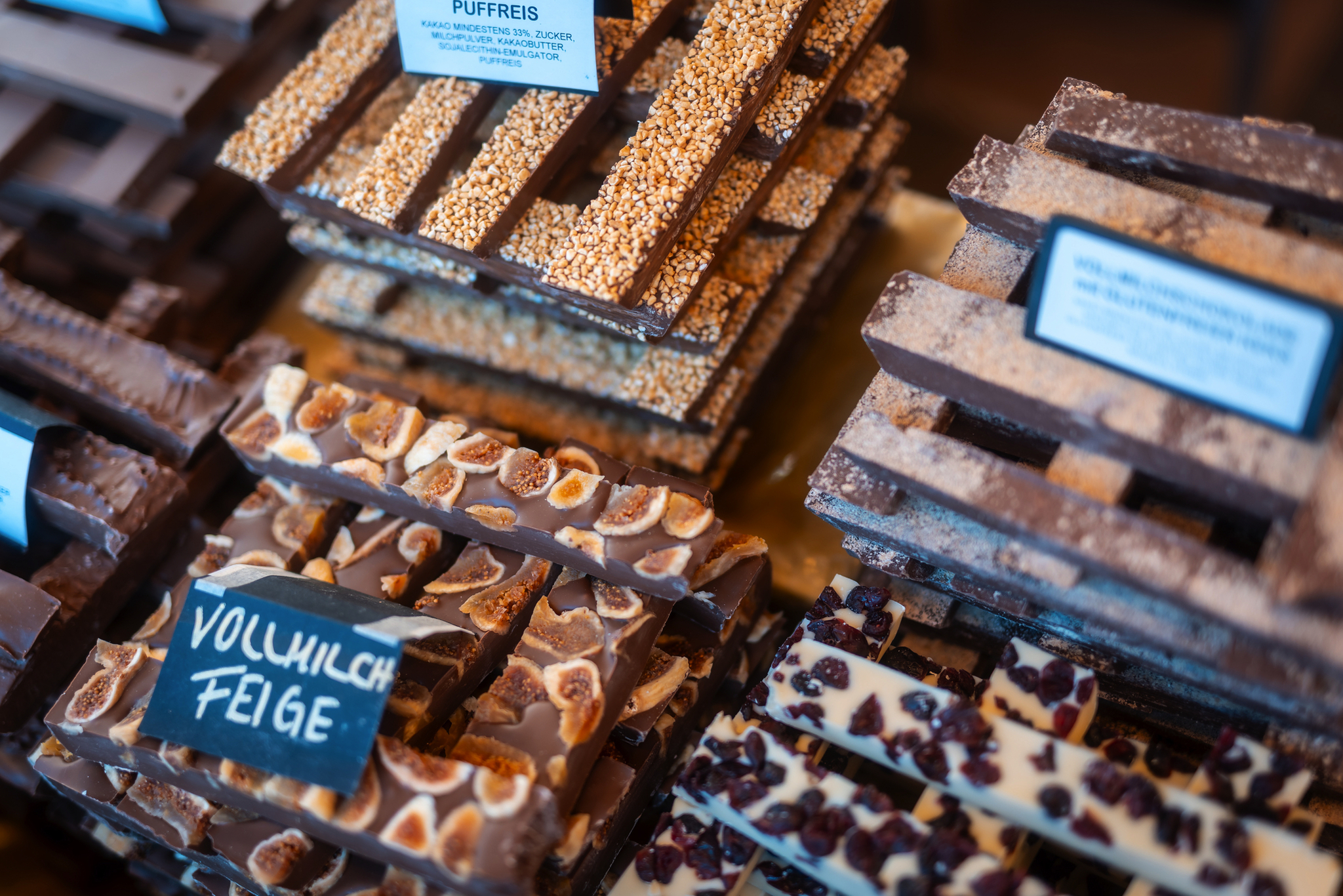 Schokoladentafeln mit verschiedenen Toppings auf einem Marktstand.