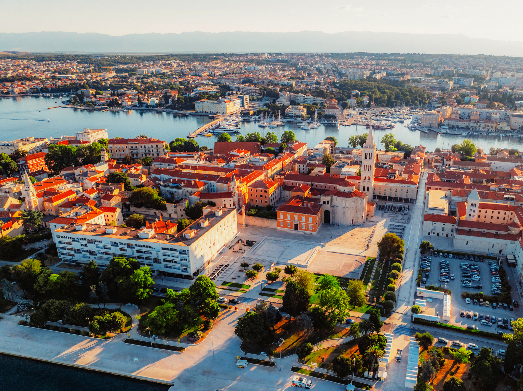 Luftaufnahme einer Küstenstadt mit historischen Gebäuden und Meeresblick.