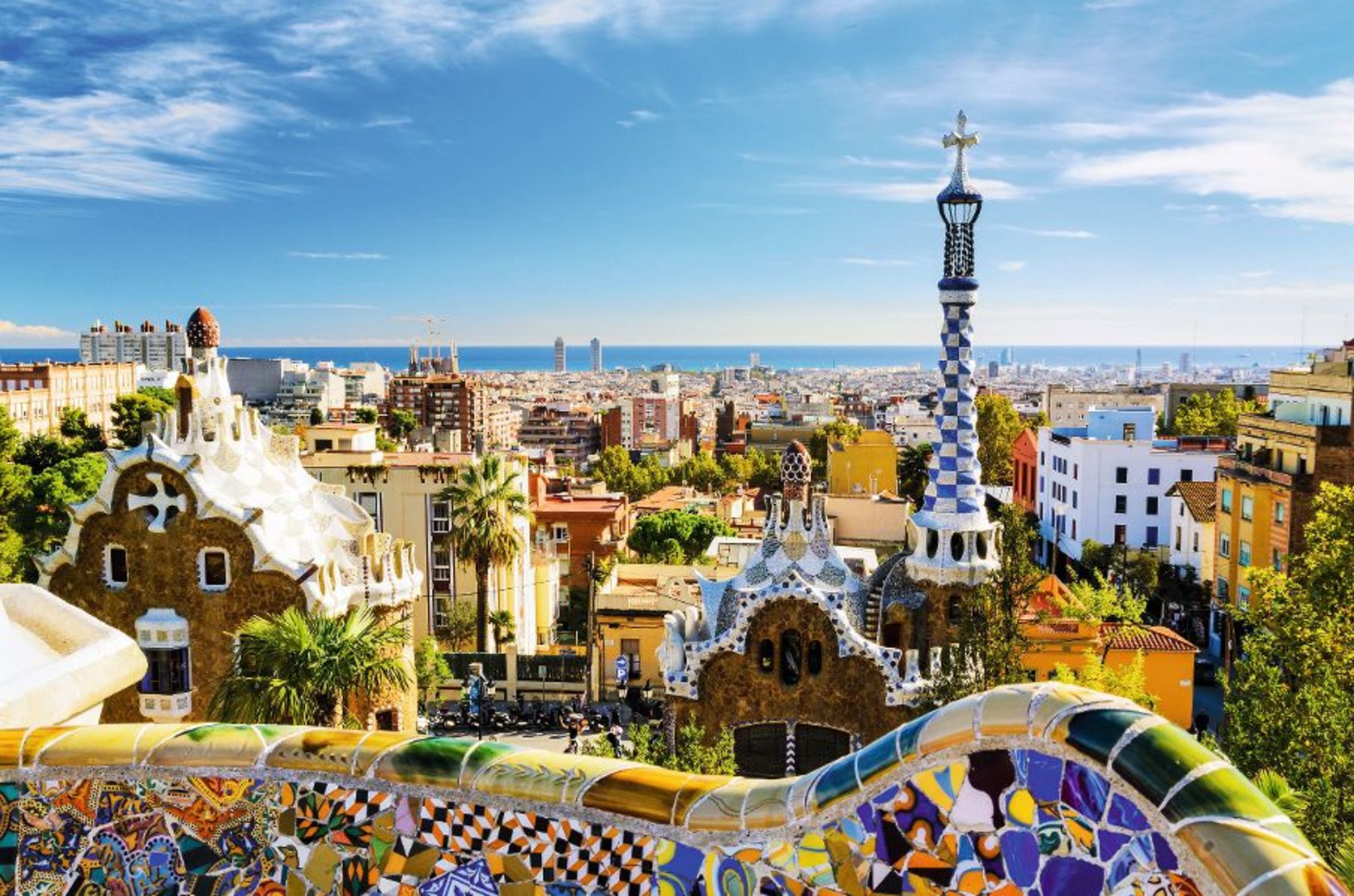 Blick über den Park Güell in Barcelona mit Stadt und Meer im Hintergrund.