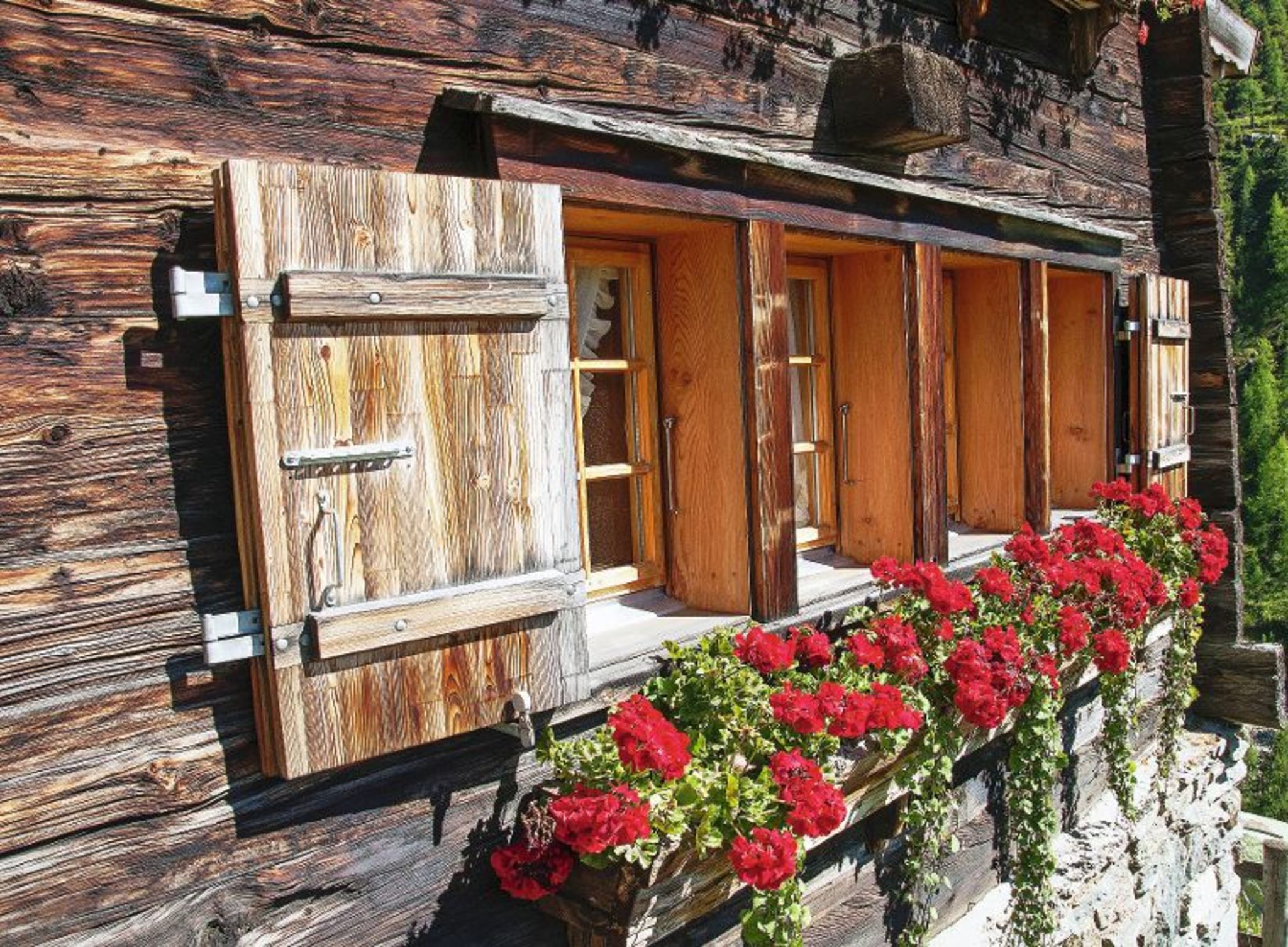 Typisches Fenster mit Blumen in den schweizer Bergen Typisches Fenster mit Blumen in den schweizer Bergen Bild