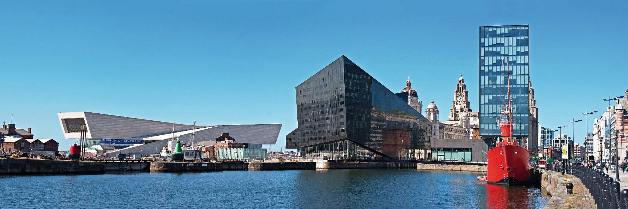 Stadtansicht mit modernen Gebäuden am Wasser und klarem Himmel.