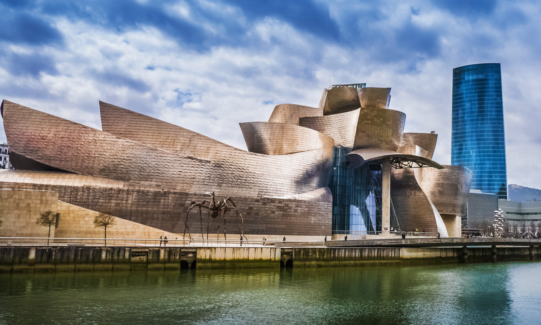 Moderne Architektur des Guggenheim-Museums in Bilbao mit Skulptur davor.