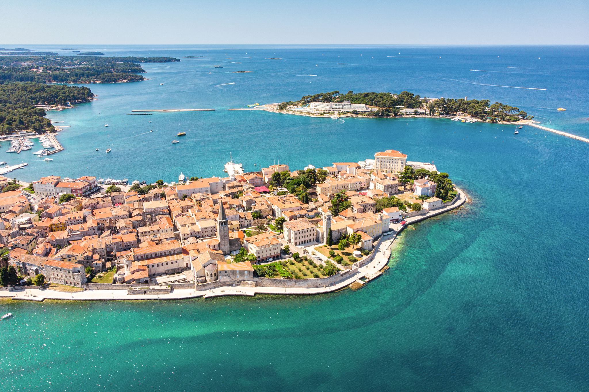 Luftaufnahme einer Küstenstadt mit historischen Gebäuden und blauem Meer.