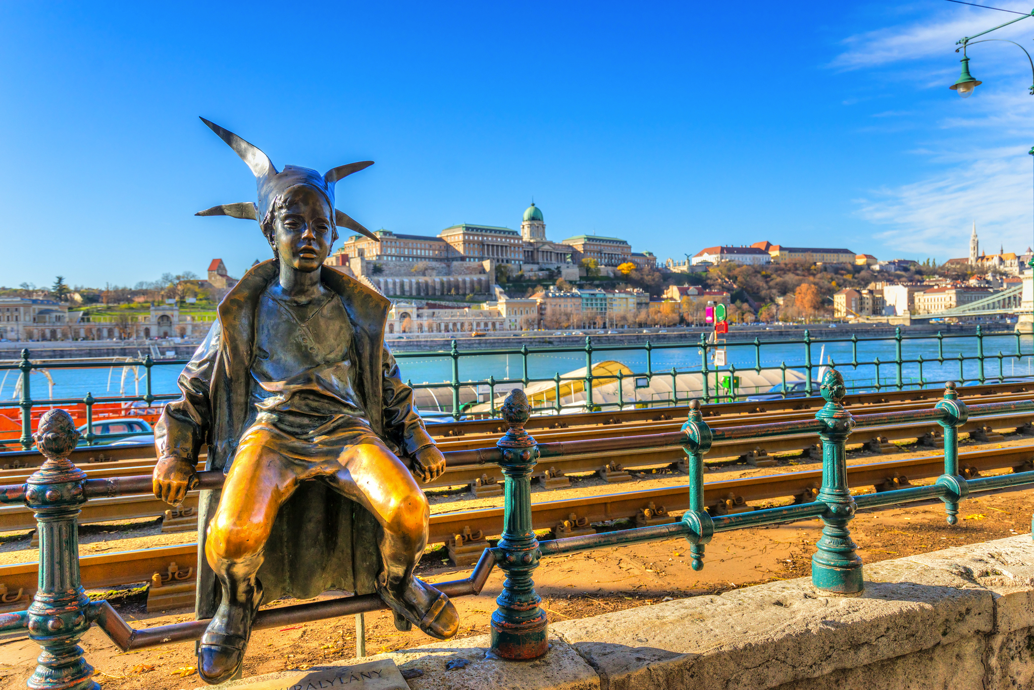 Bronzestatue eines Mädchens am Flussufer, Budapest im Hintergrund.