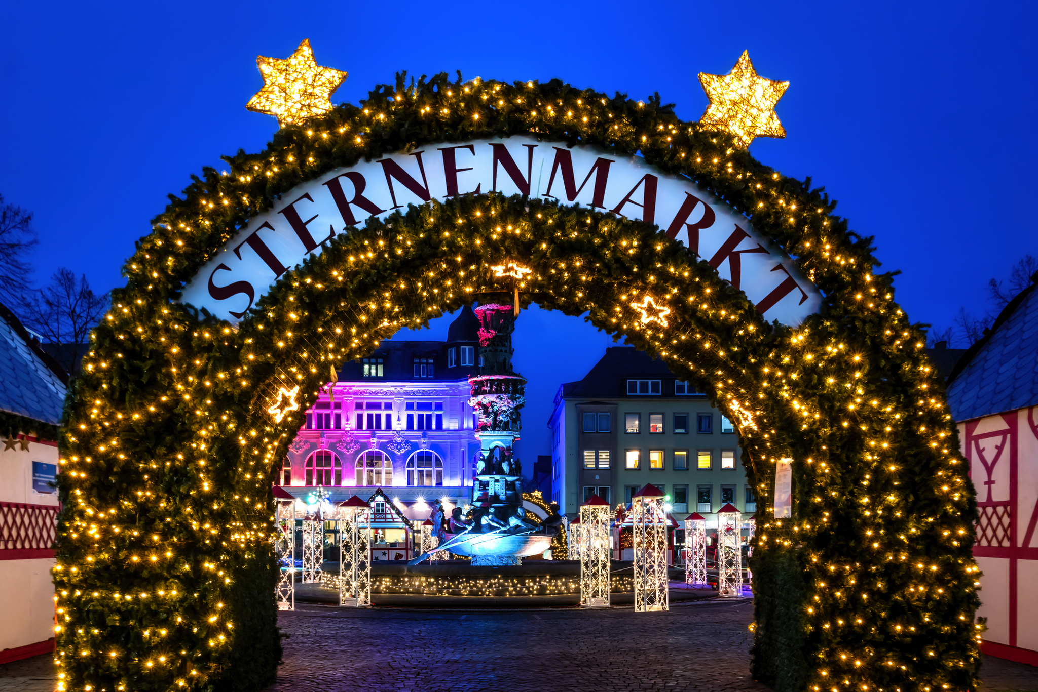 Weihnachtsmarkt-Eingang bei Nacht mit Lichterdekoration.
