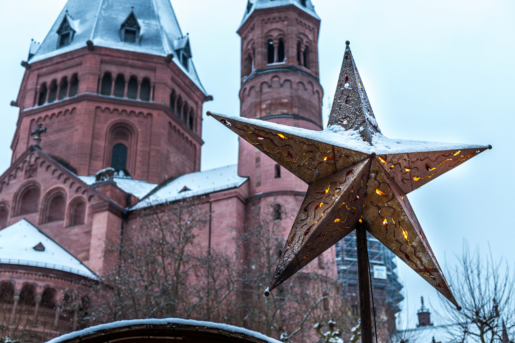 Sternendekoration vor schneebedeckter Kathedrale im Winter.
