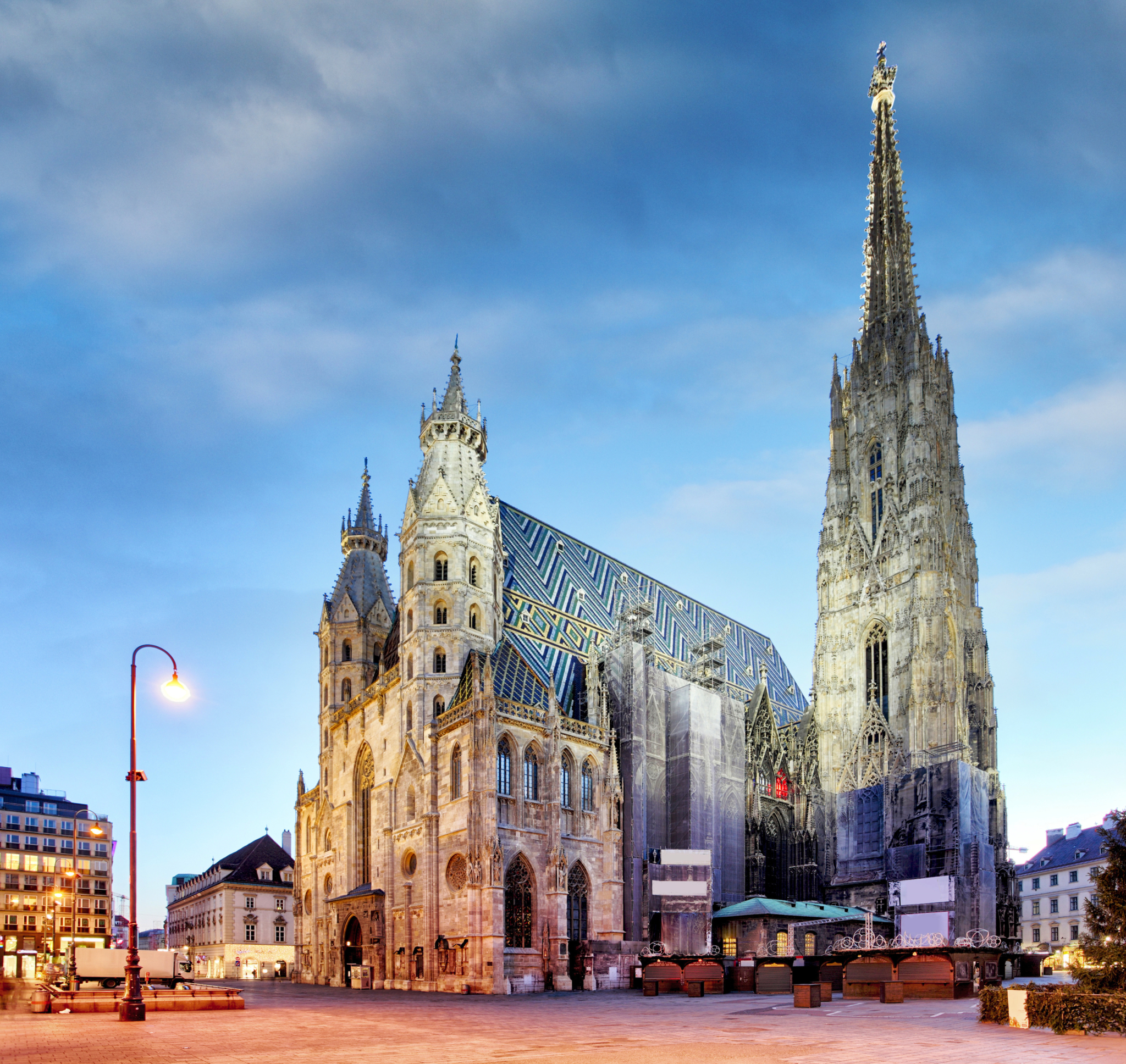 Stephansdom in Wien bei Dämmerung mit beleuchtetem Platz und blauem Himmel im Hintergrund.