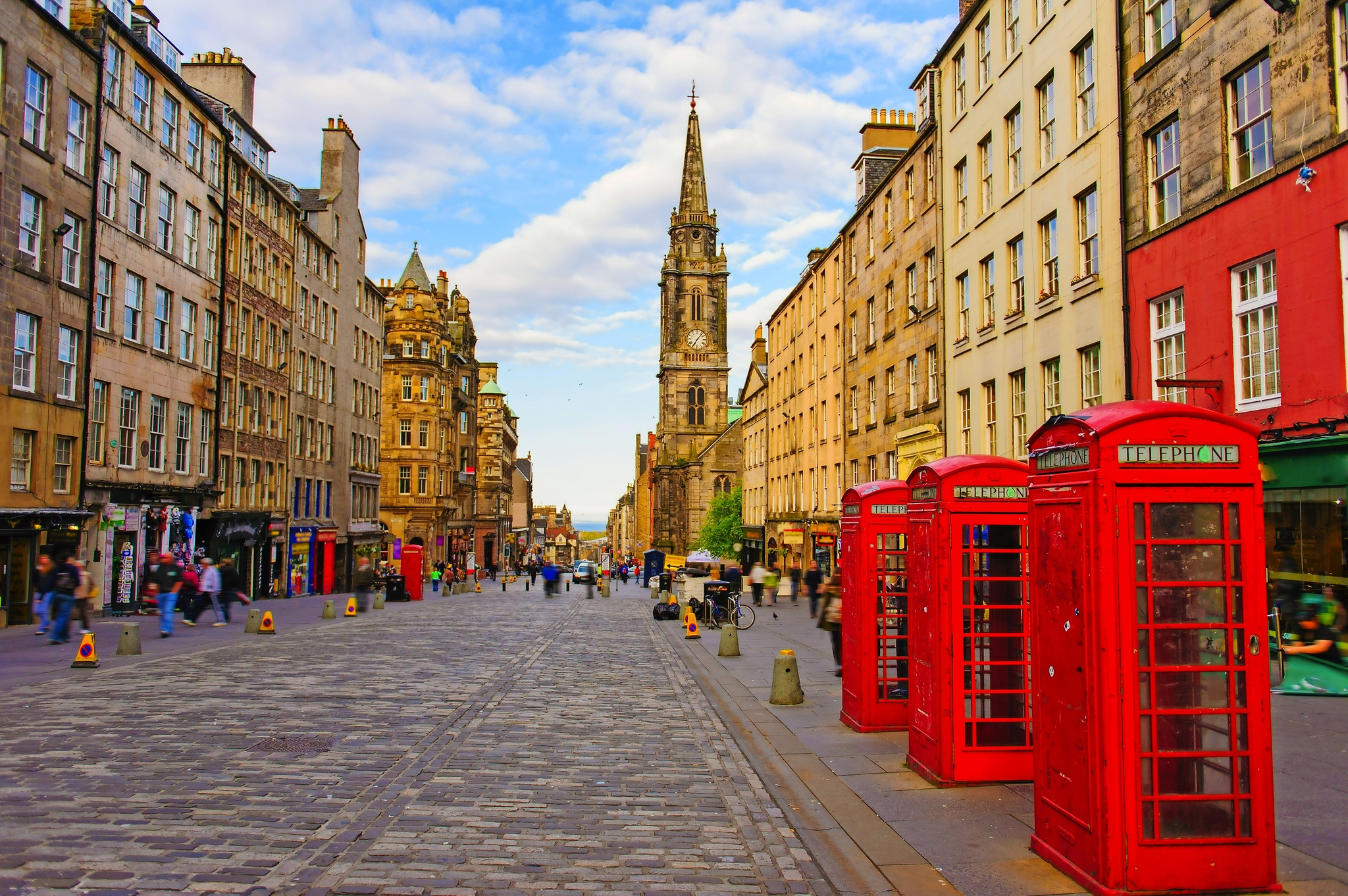 Straßenszene in Edinburgh mit roten Telefonzellen und historischer Architektur.