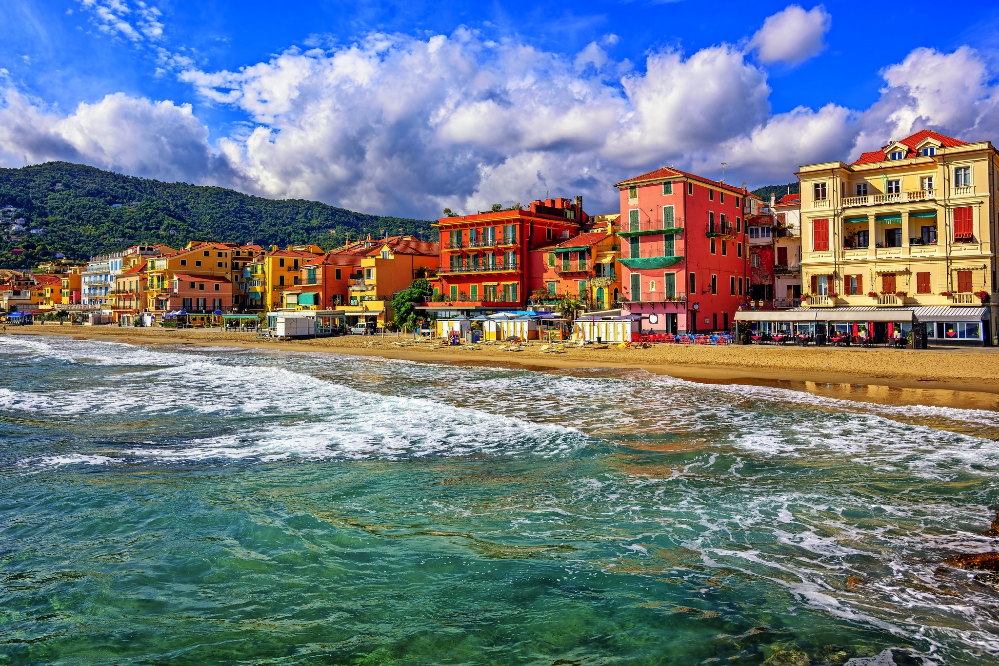 Bunte Gebäude am Meer mit bewölktem Himmel im Hintergrund.