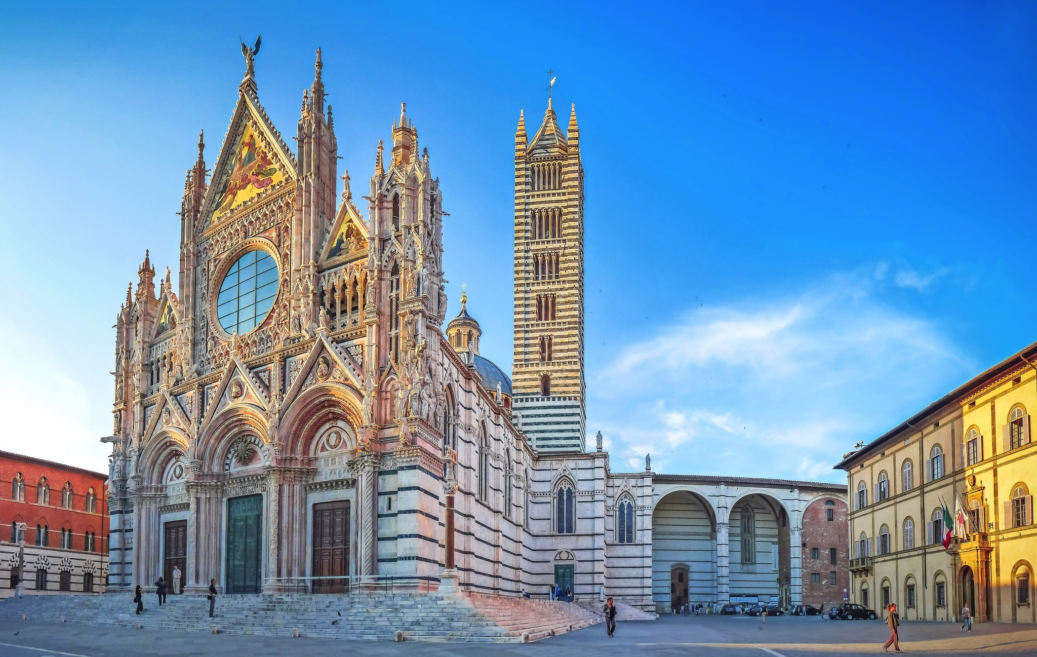 Kathedrale von Siena mit ihrem kunstvollen gotischen Fassadendesign bei klarem Himmel.
