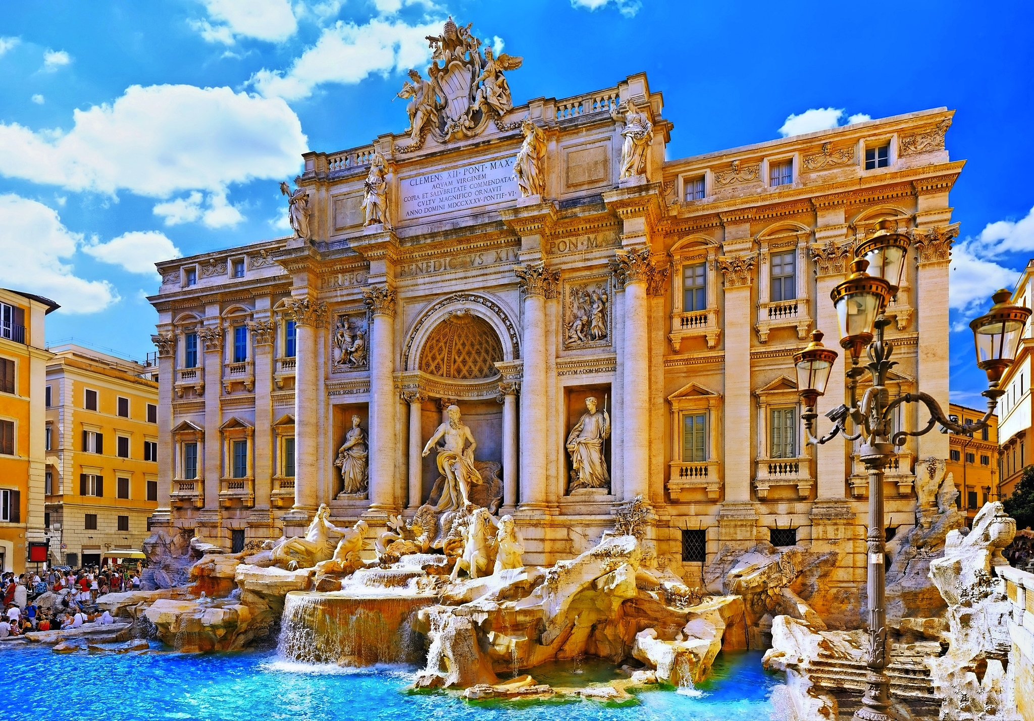 Brunnen vor einem barocken Palast mit Statuen und blauem Himmel.
