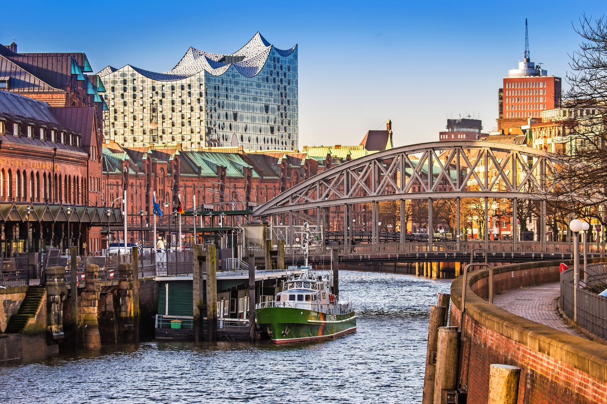 Blick auf Hamburger Hafencity mit Brücke und Elbphilharmonie im Hintergrund.