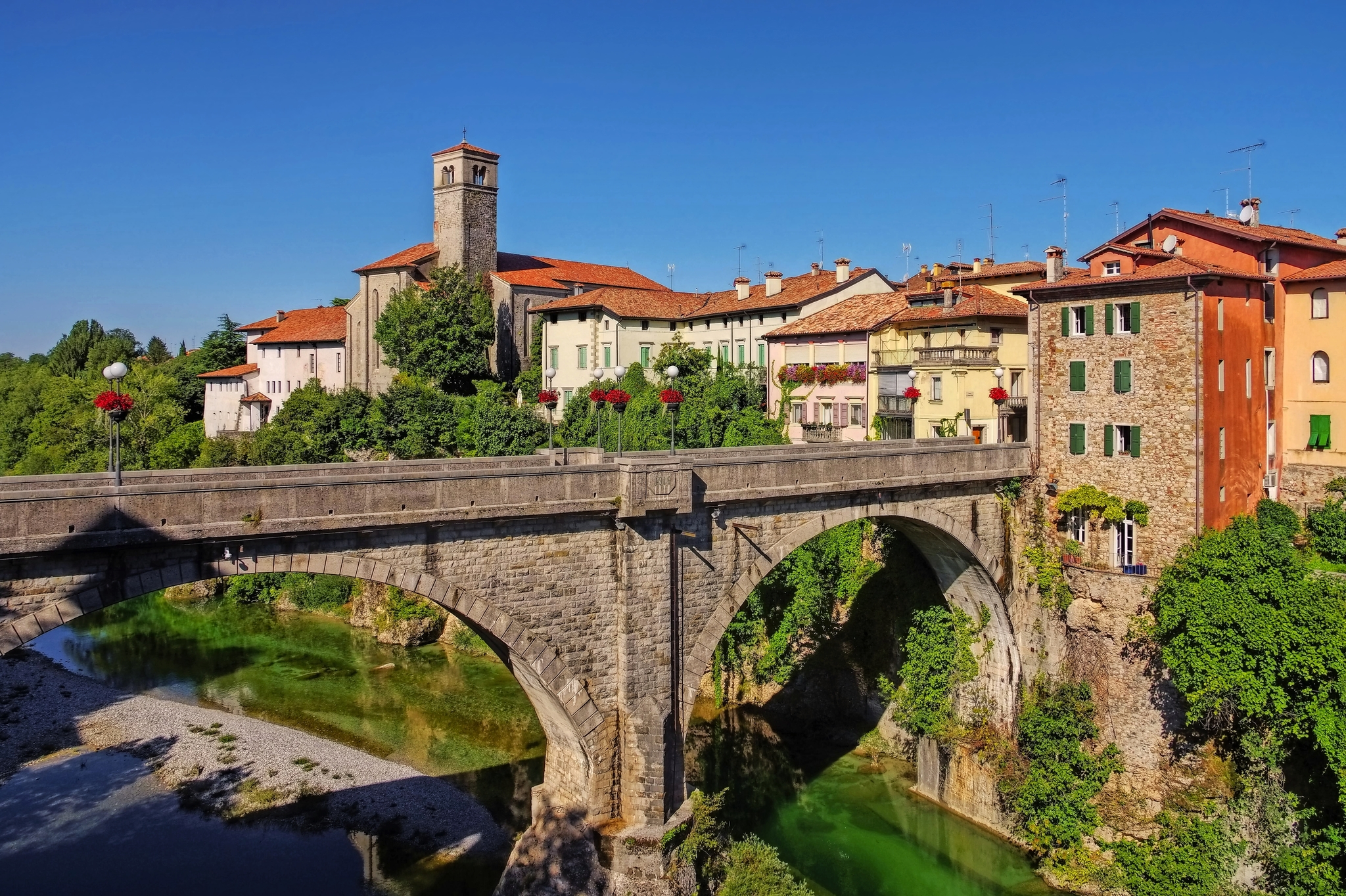 Steinbrücke über einen Fluss mit historischen Gebäuden im Hintergrund.