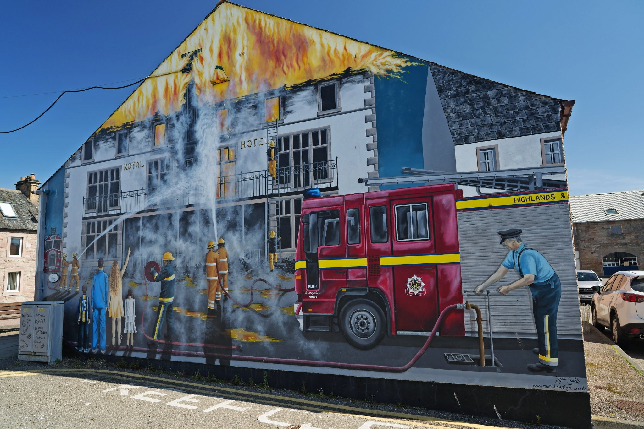 Wandgemälde zeigt Feuerwehrleute vor brennendem Gebäude mit Feuerwehrauto.