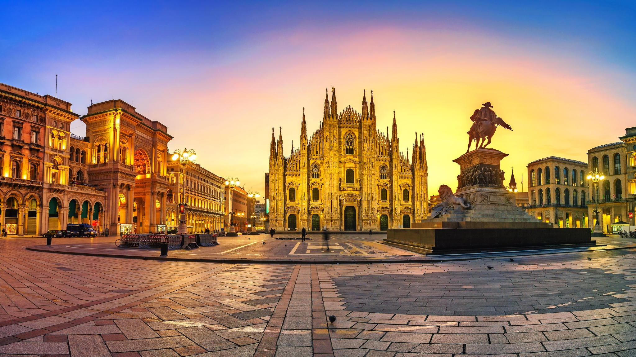 Milans Domplatz bei Sonnenuntergang mit prächtigem Gebäude und Reiterdenkmal.