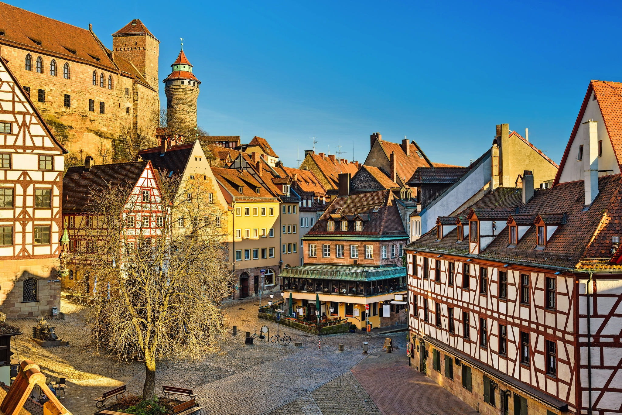 Historische Altstadt mit Fachwerkhäusern und Burg im Hintergrund.