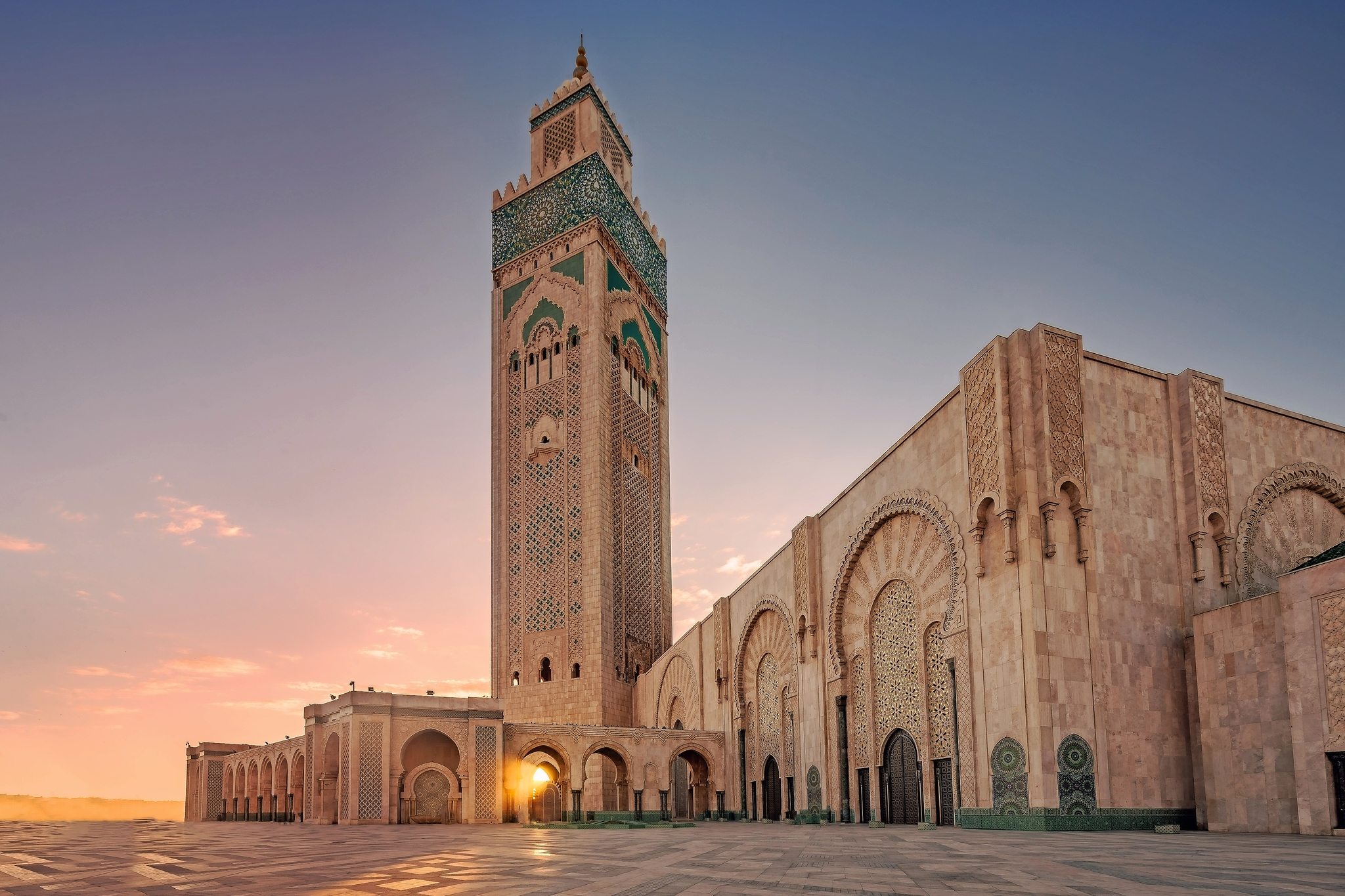 Große Moschee bei Sonnenuntergang mit Mosaikverzierungen und Minarett.