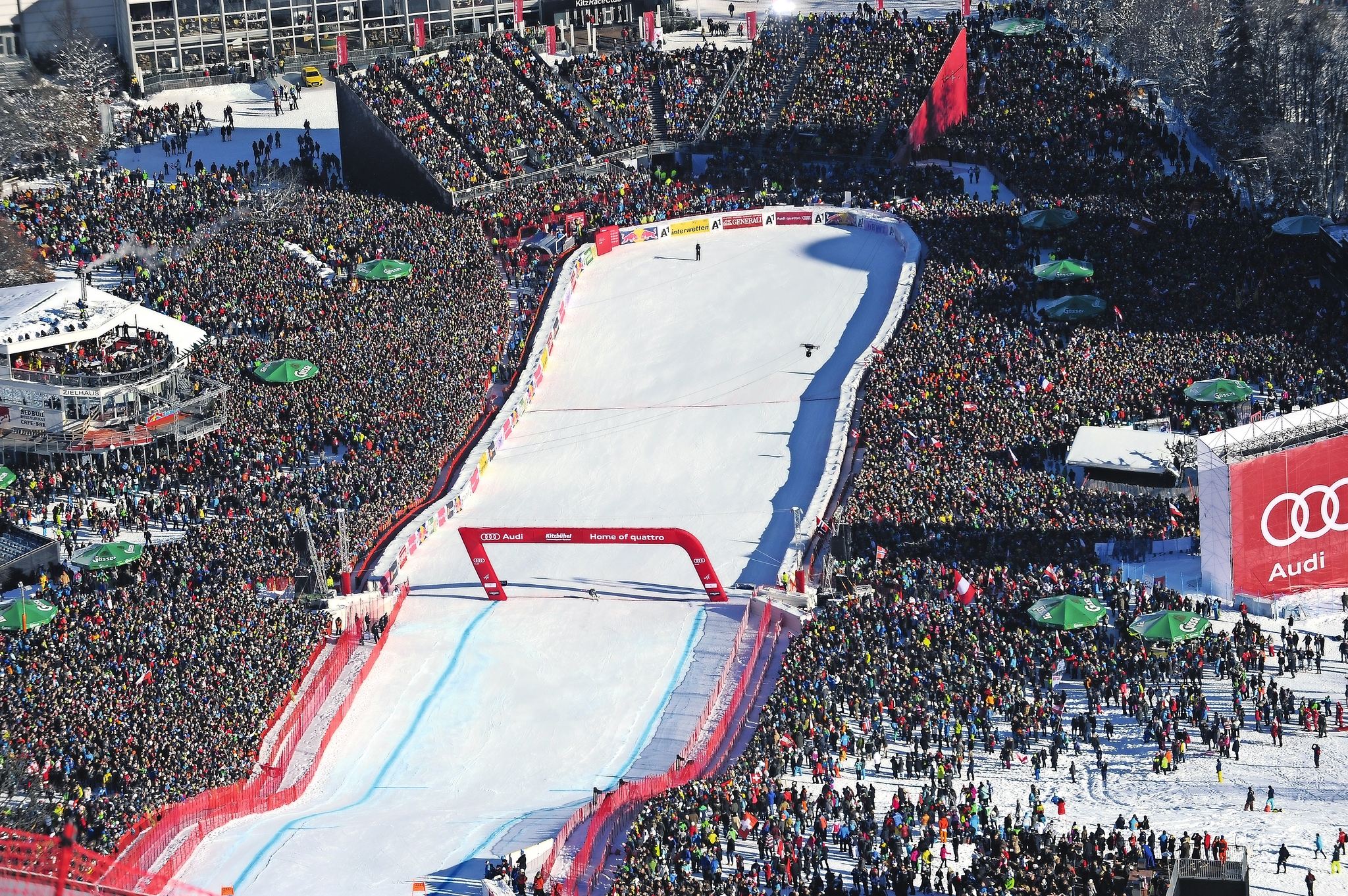 Viele Zuschauer bei einem Skirennen auf einer verschneiten Skipiste.