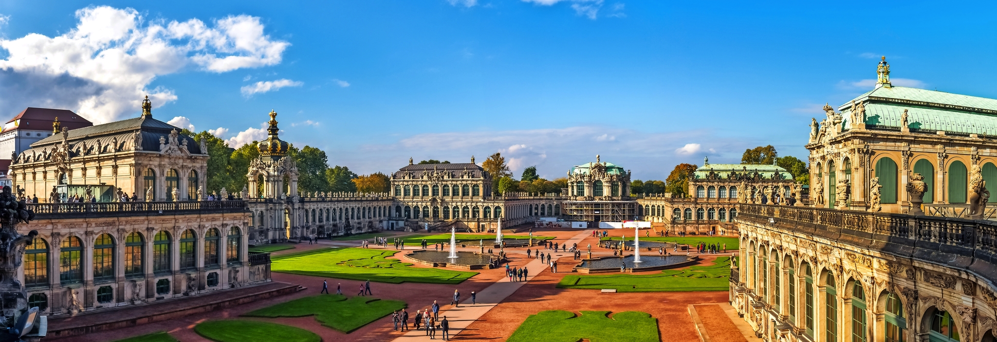 Barocke Architektur des Dresdner Zwingers bei sonnigem Wetter, Menschen auf dem Platz.